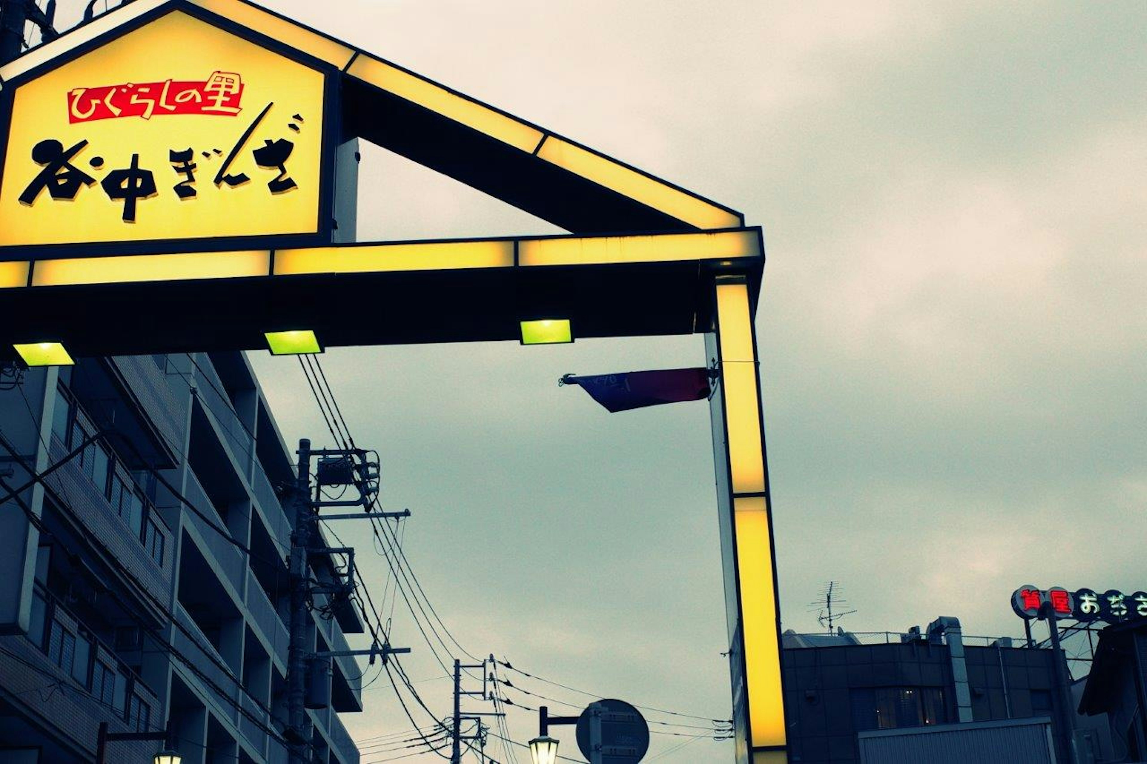 Yellow arch-shaped sign with cloudy skyline