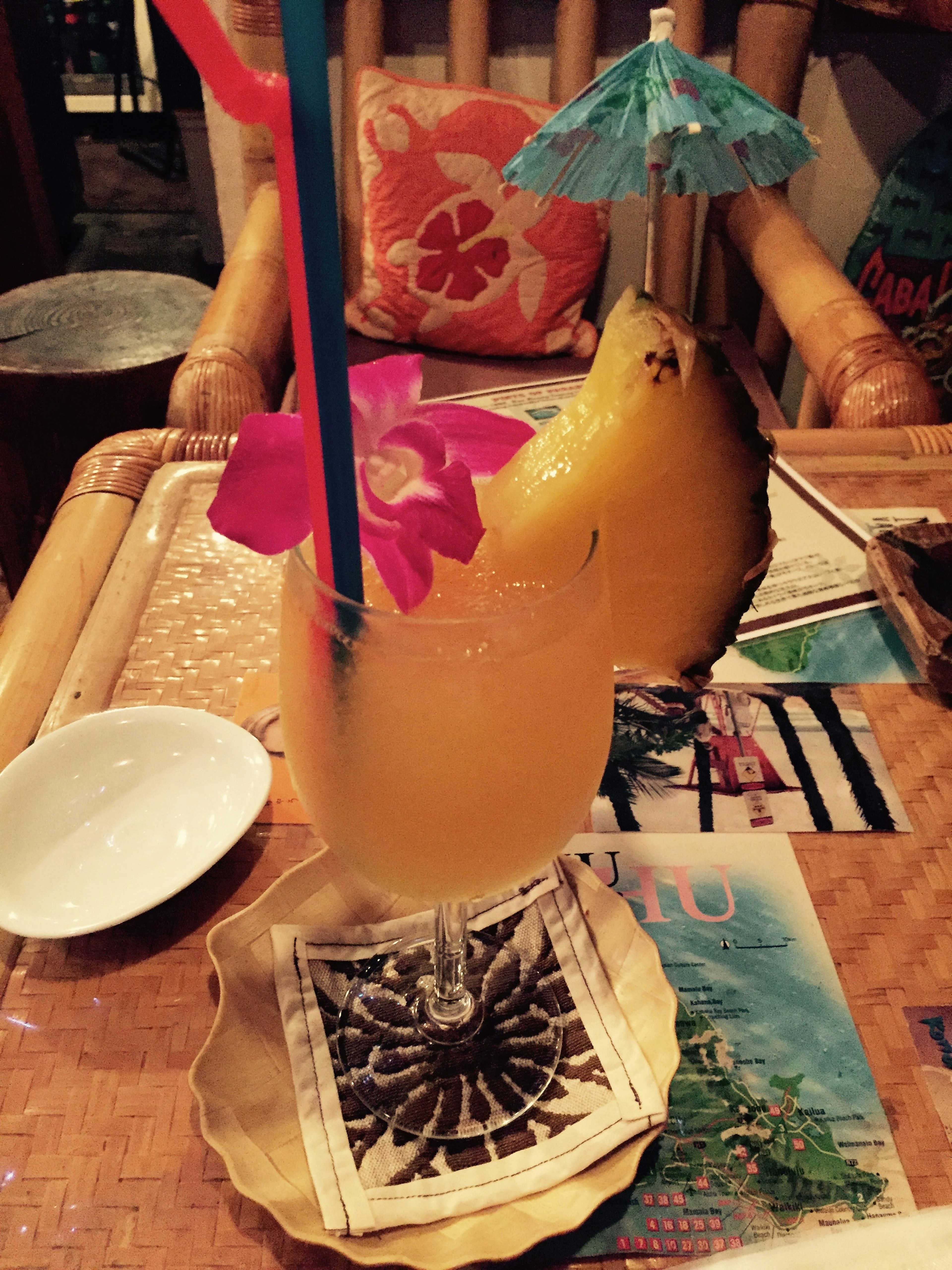 Colorful cocktail garnished with pineapple and flower on a table