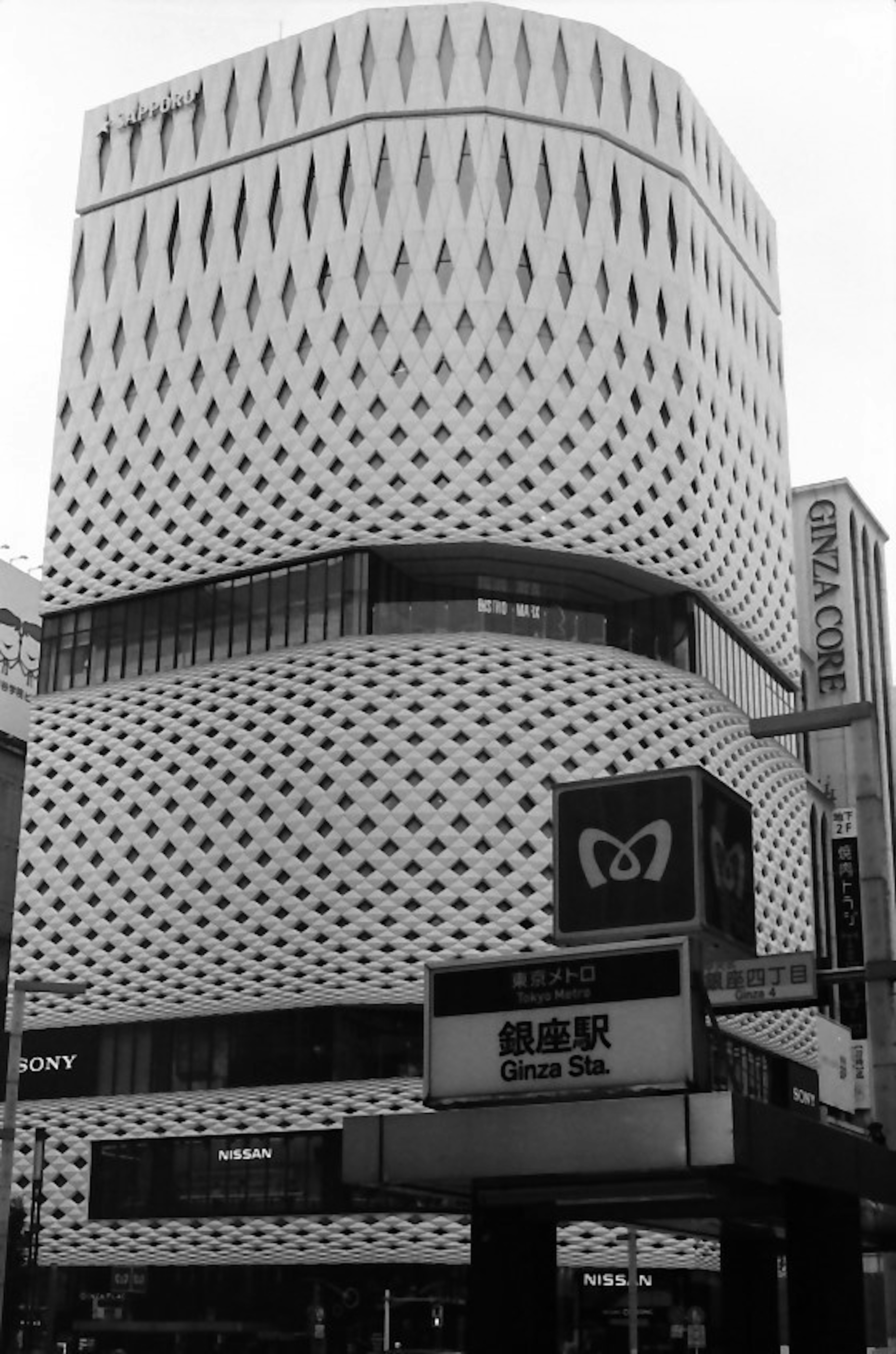 Bâtiment moderne avec une façade blanche ornée de motifs en forme de diamant