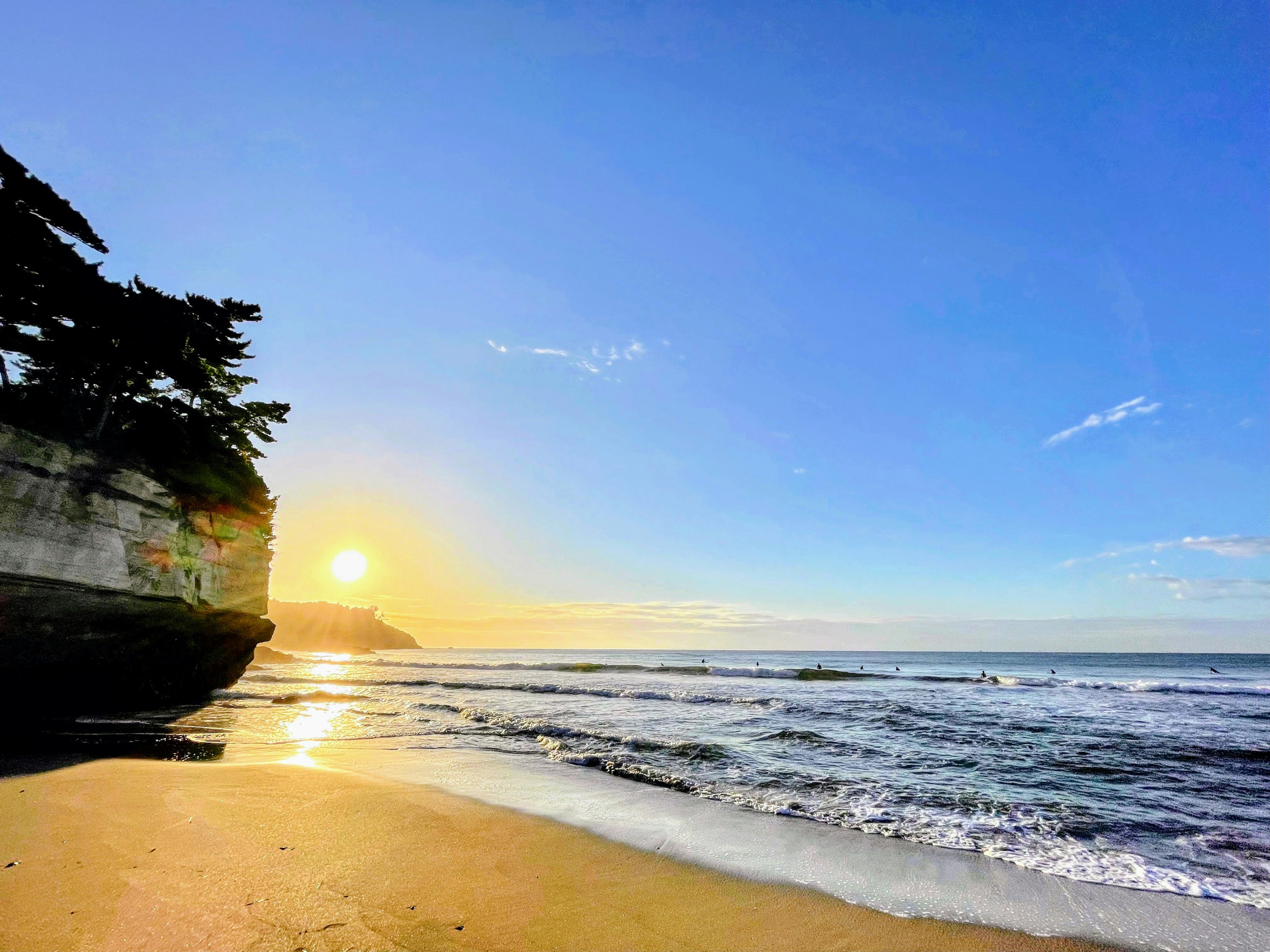 Garis pantai yang indah dengan matahari terbenam dan ombak lembut