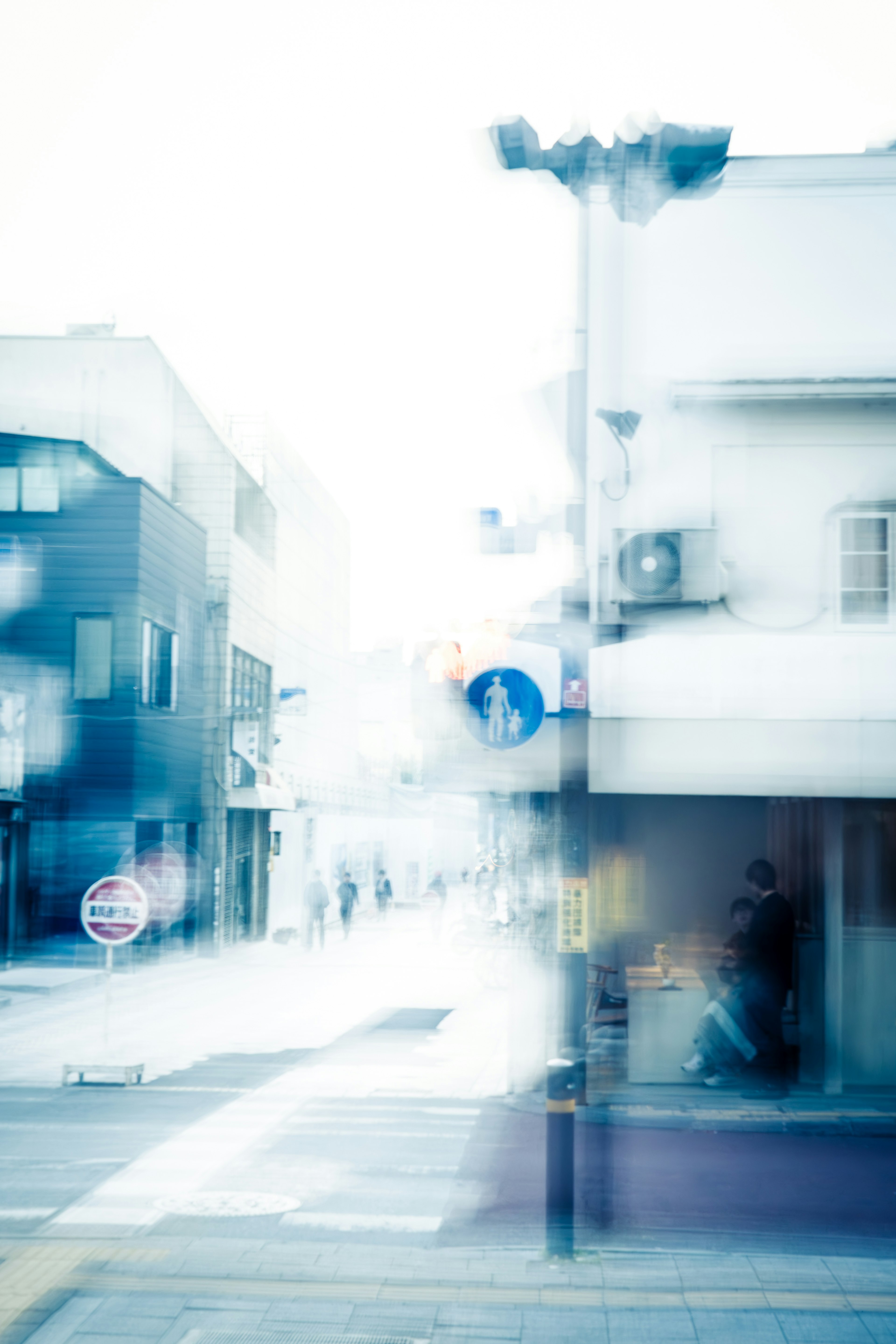 ぼやけた街の風景と人々の動きがある