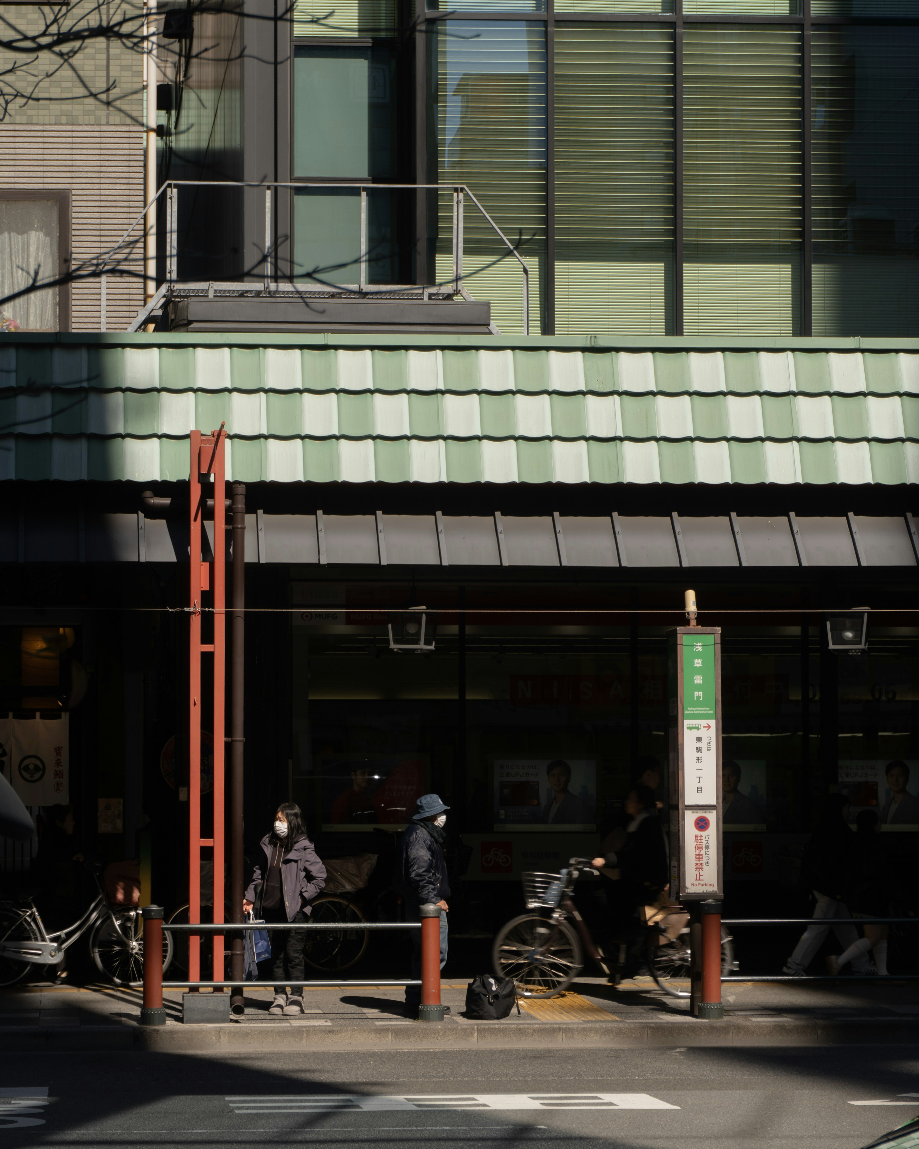 緑の屋根のカフェの外観に人々が集まる様子