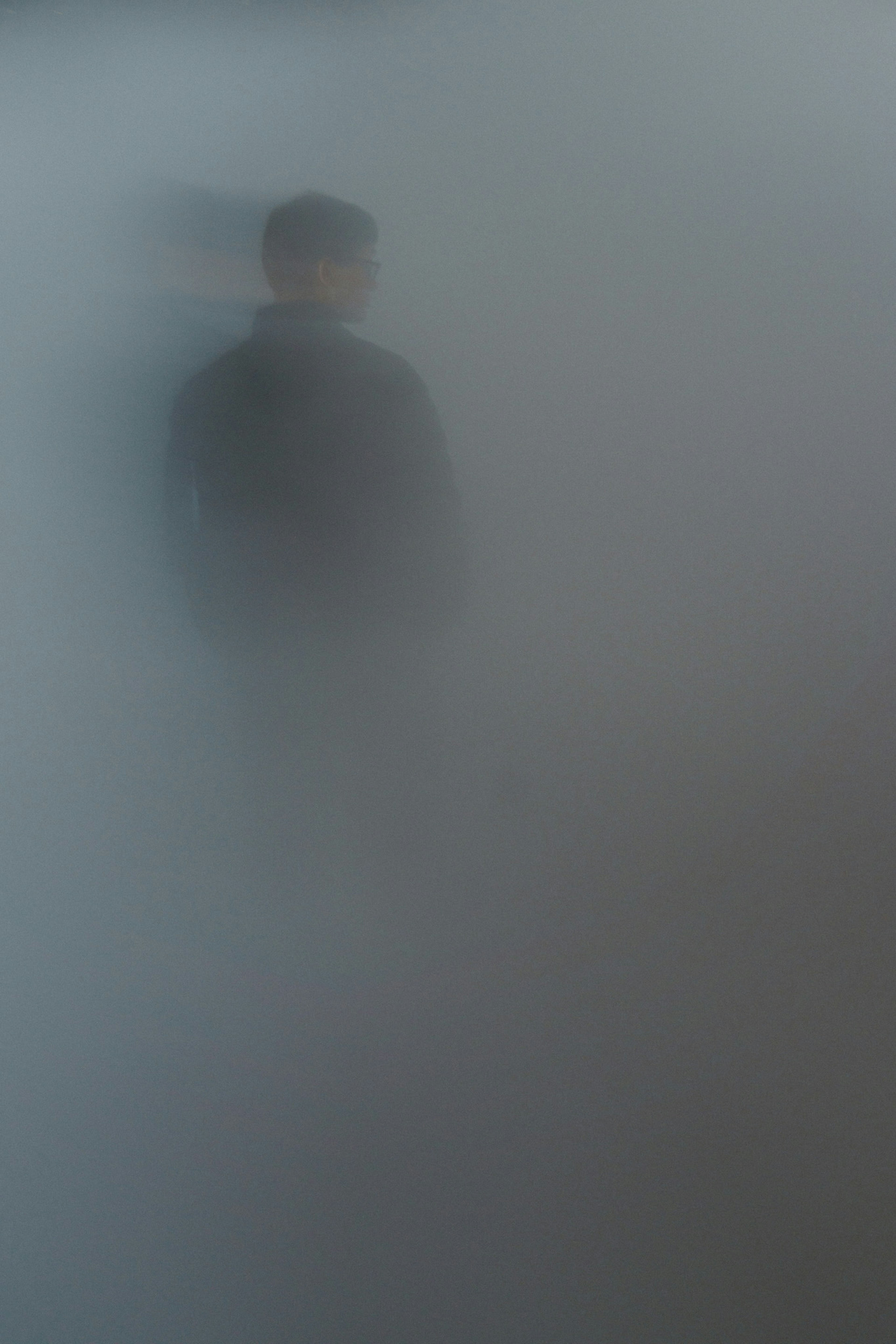 Silhouette d'une personne se tenant dans le brouillard