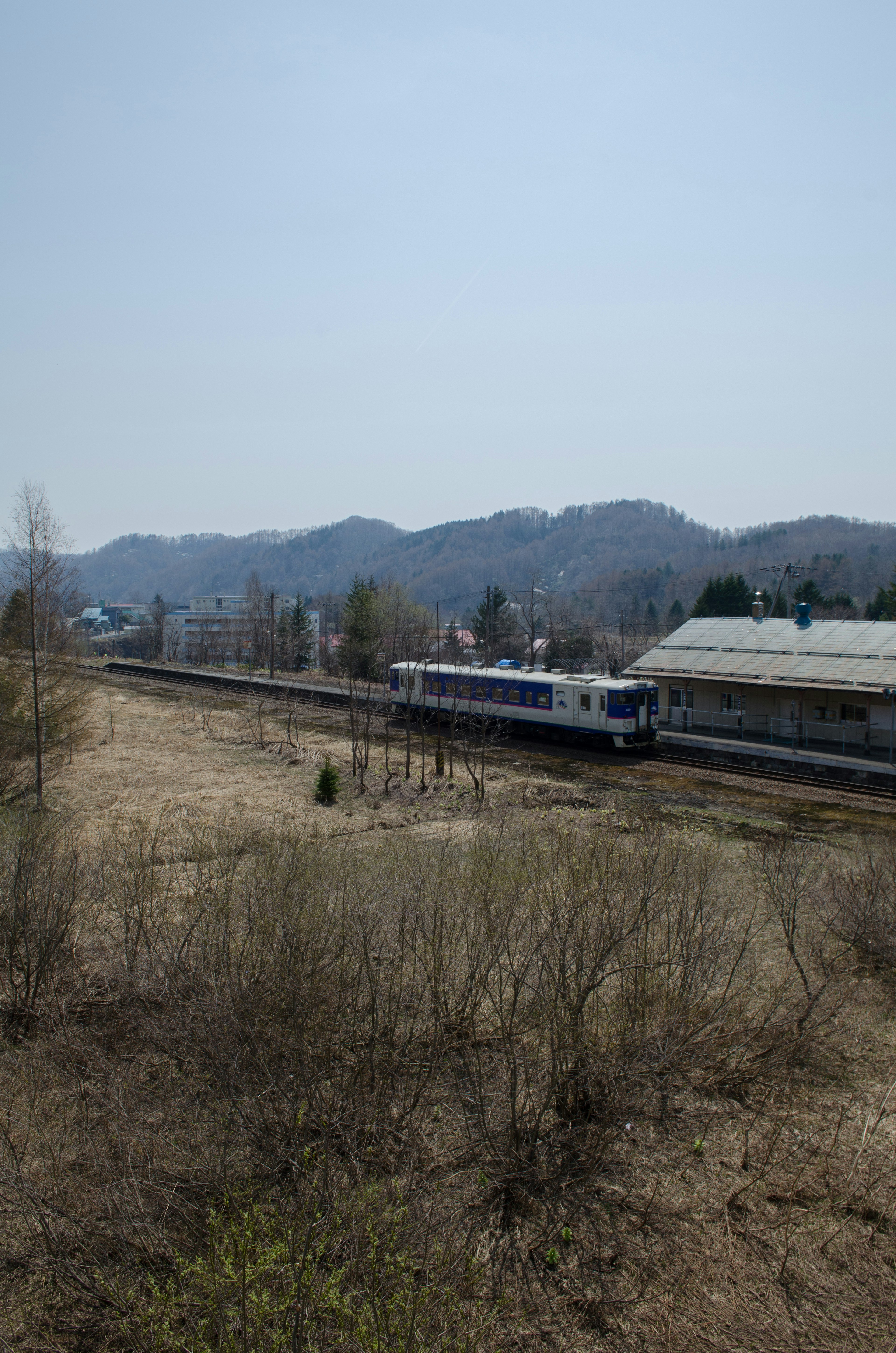 Train traveling along tracks with mountains in the background