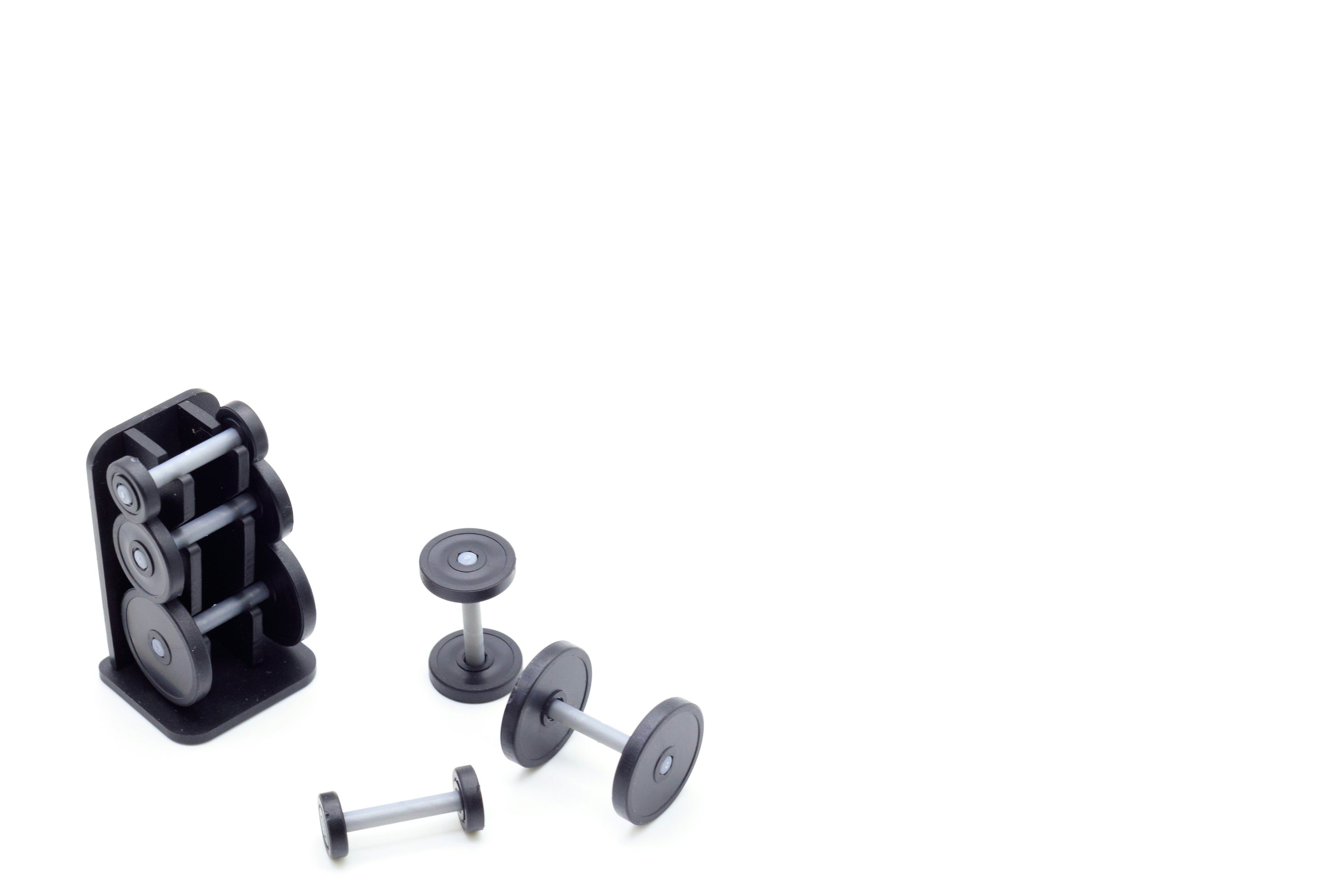 A set of black dumbbells and weight plates arranged on a white background