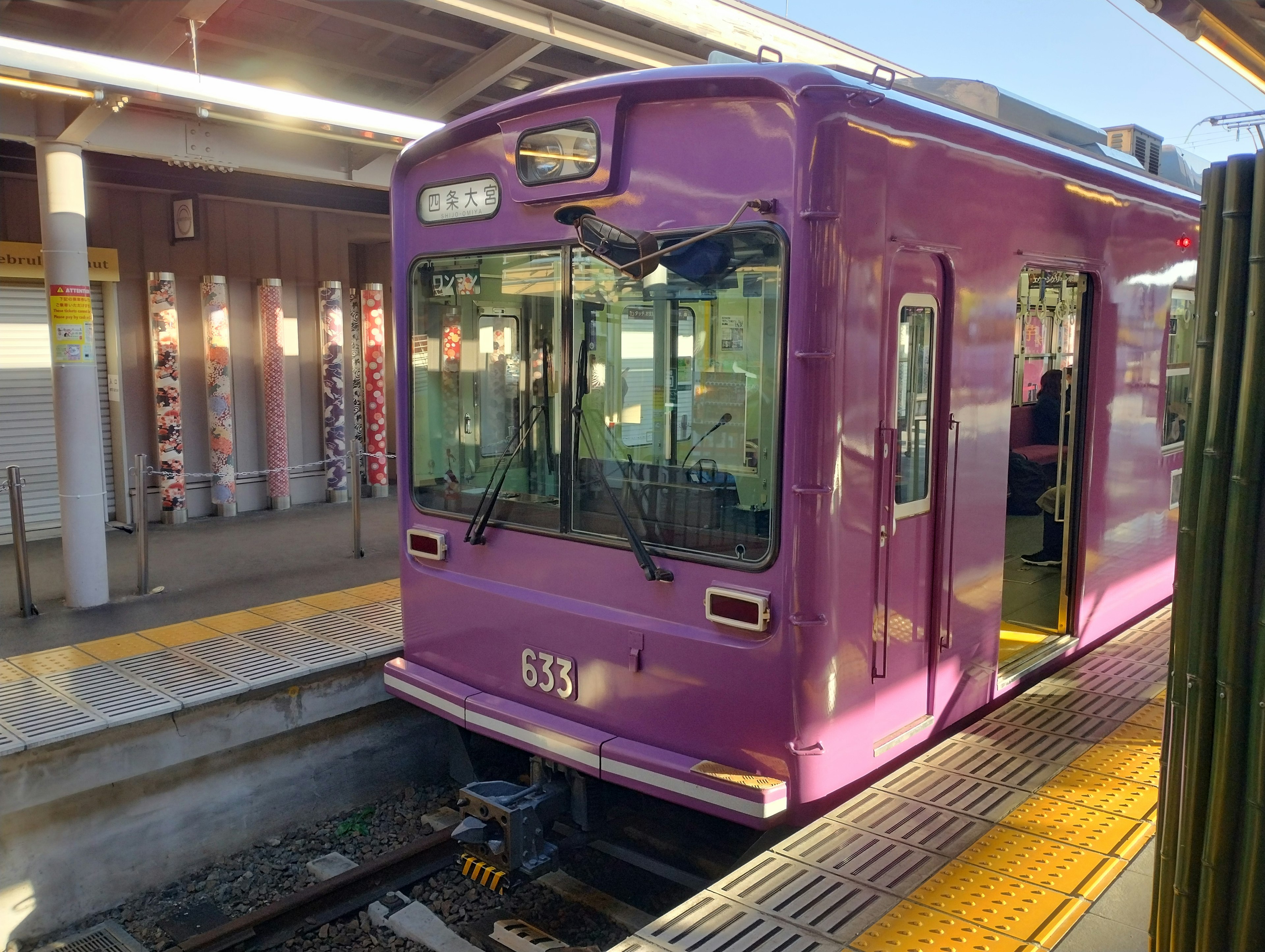 Sebuah kereta ungu berhenti di stasiun