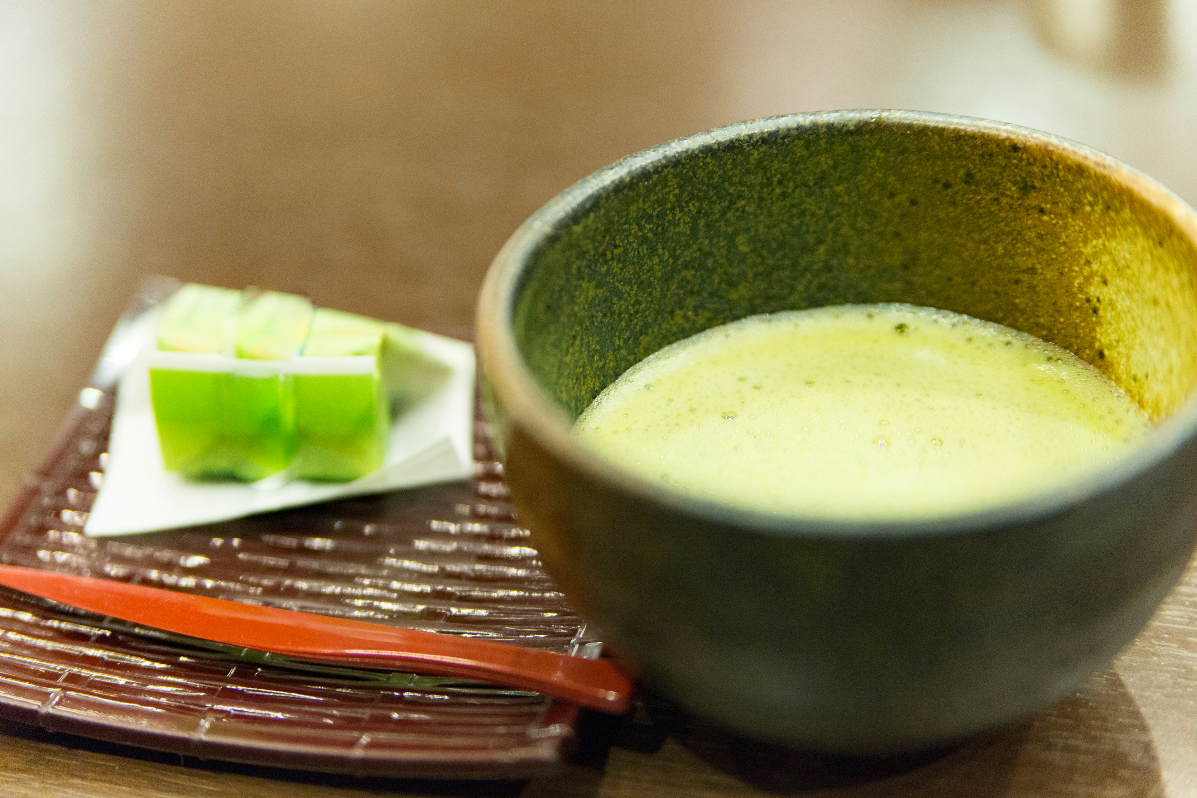 Cuenco verde lleno de sopa y un postre verde en un plato