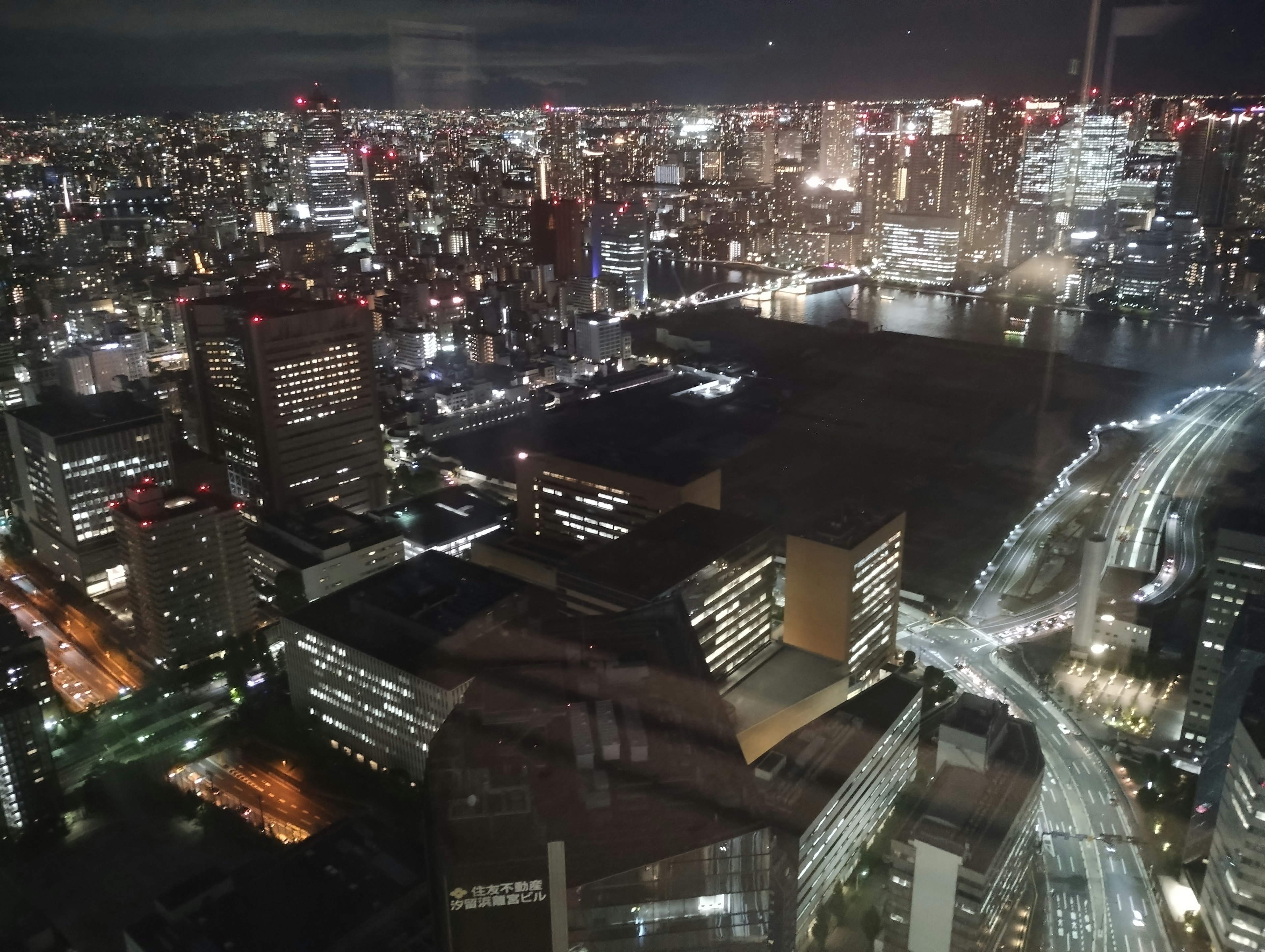 Pemandangan kota malam dengan gedung pencakar langit yang diterangi di Tokyo