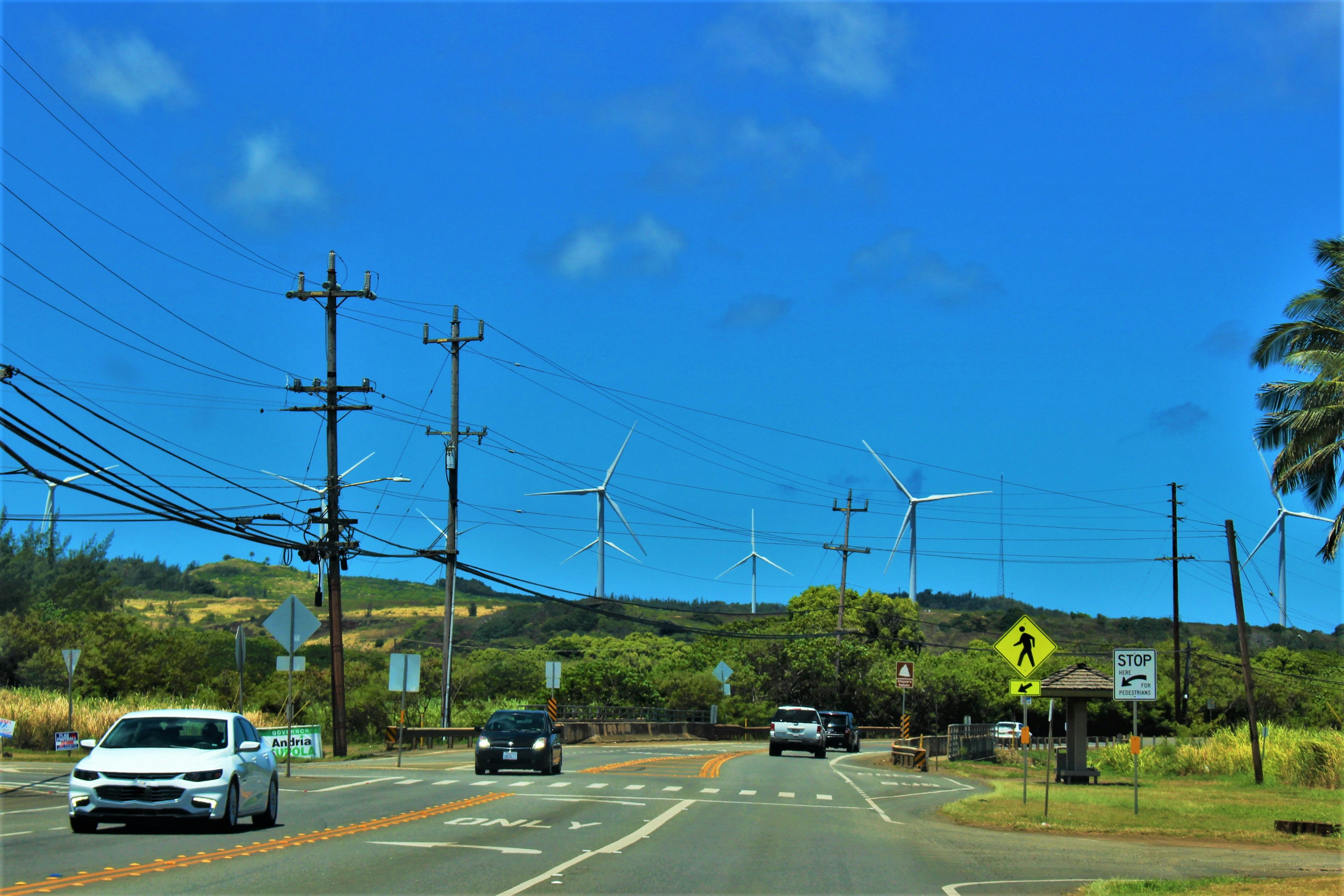 Road scene with wind turbines under a blue sky