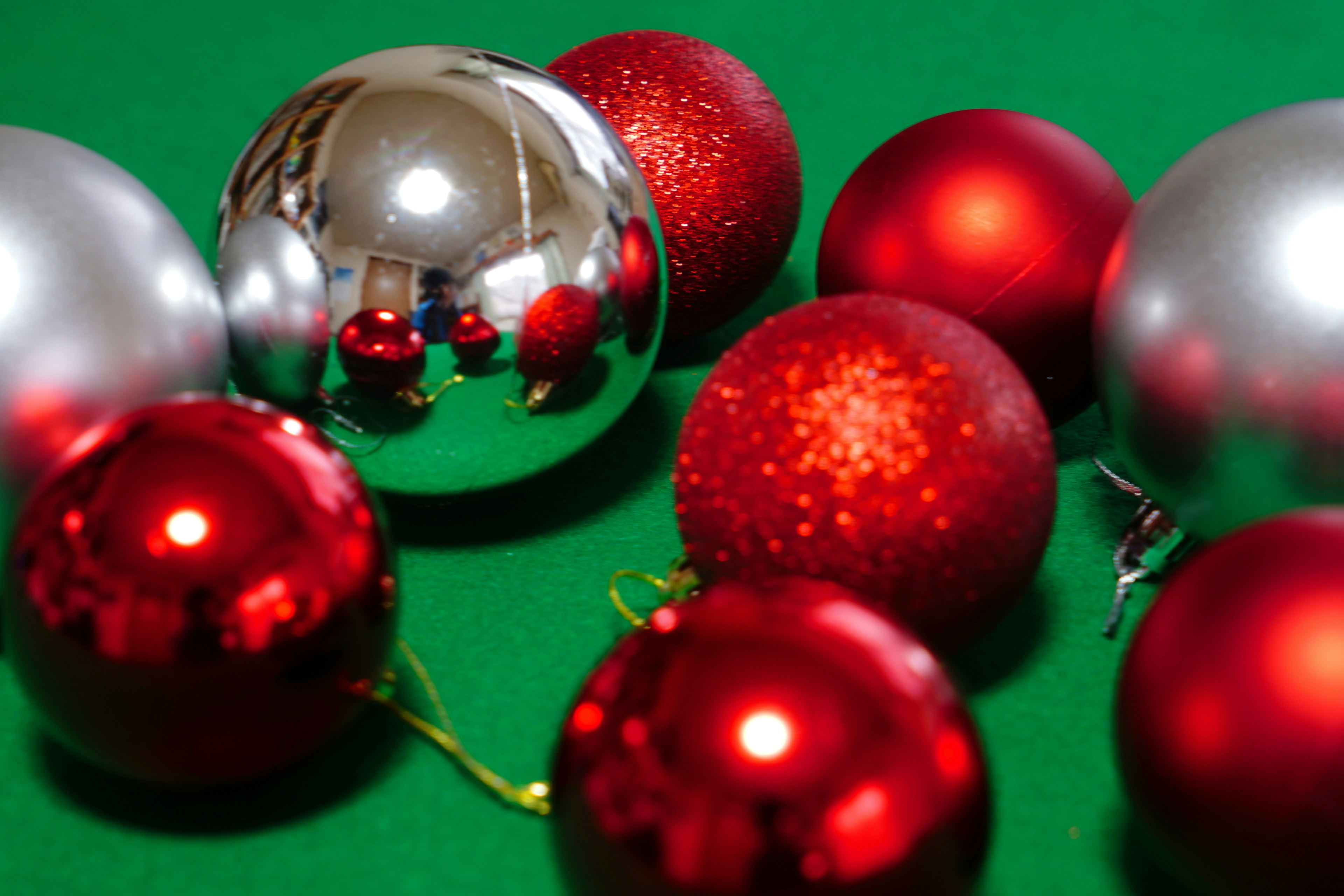 Red and silver Christmas ornaments on a green surface