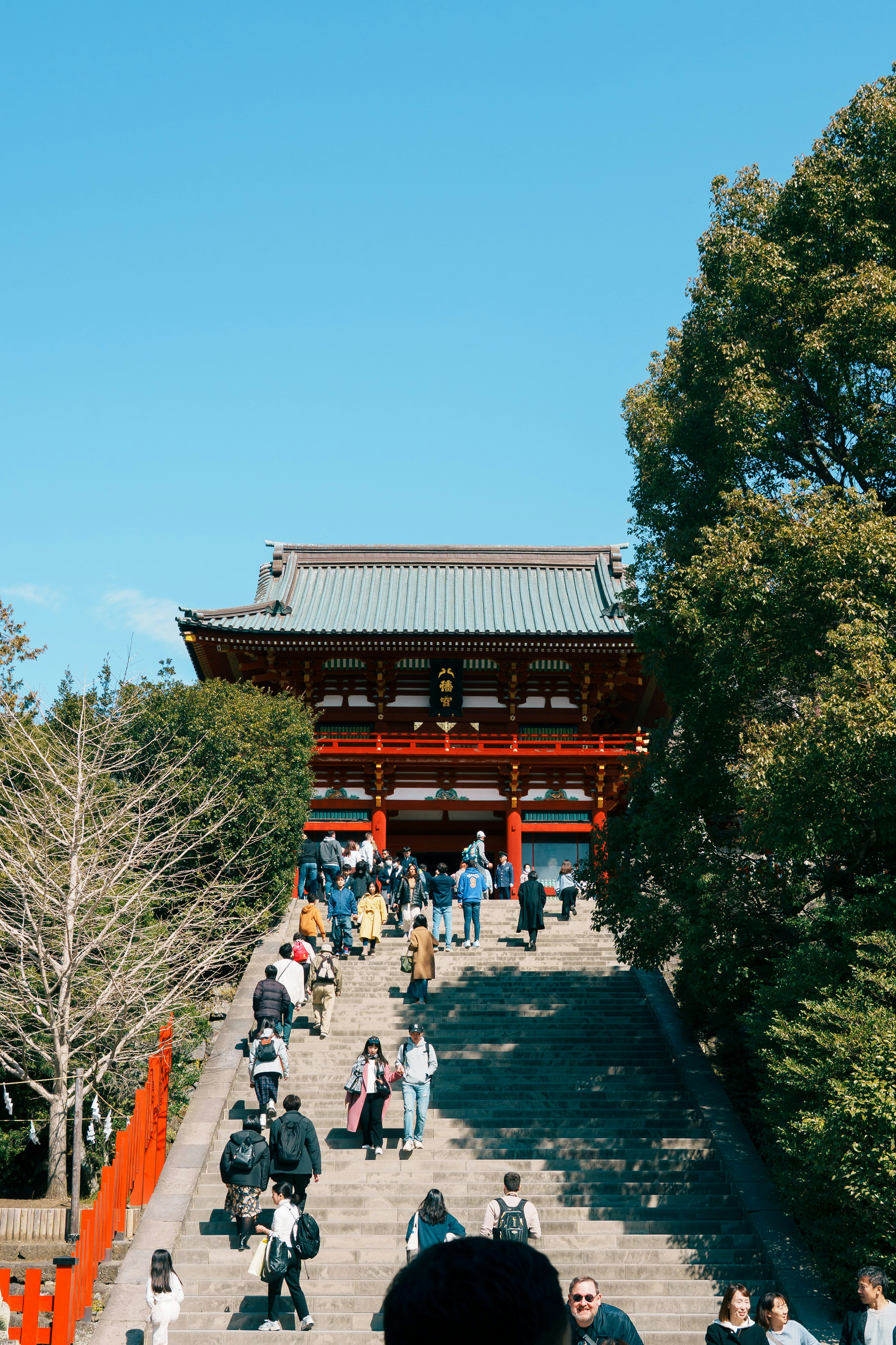 赤い門を背景にした階段を上る人々の風景