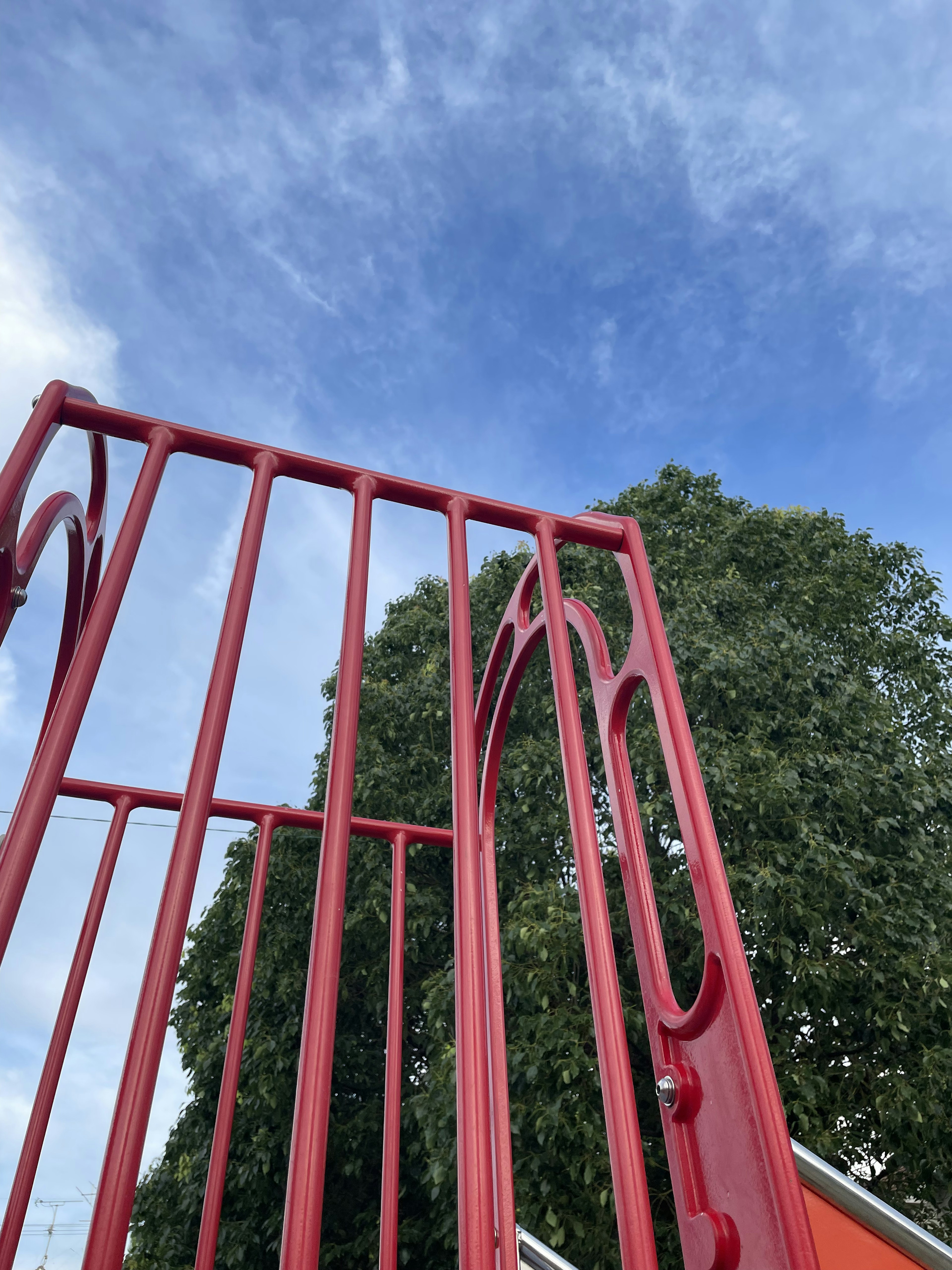 Red playground structure against a blue sky