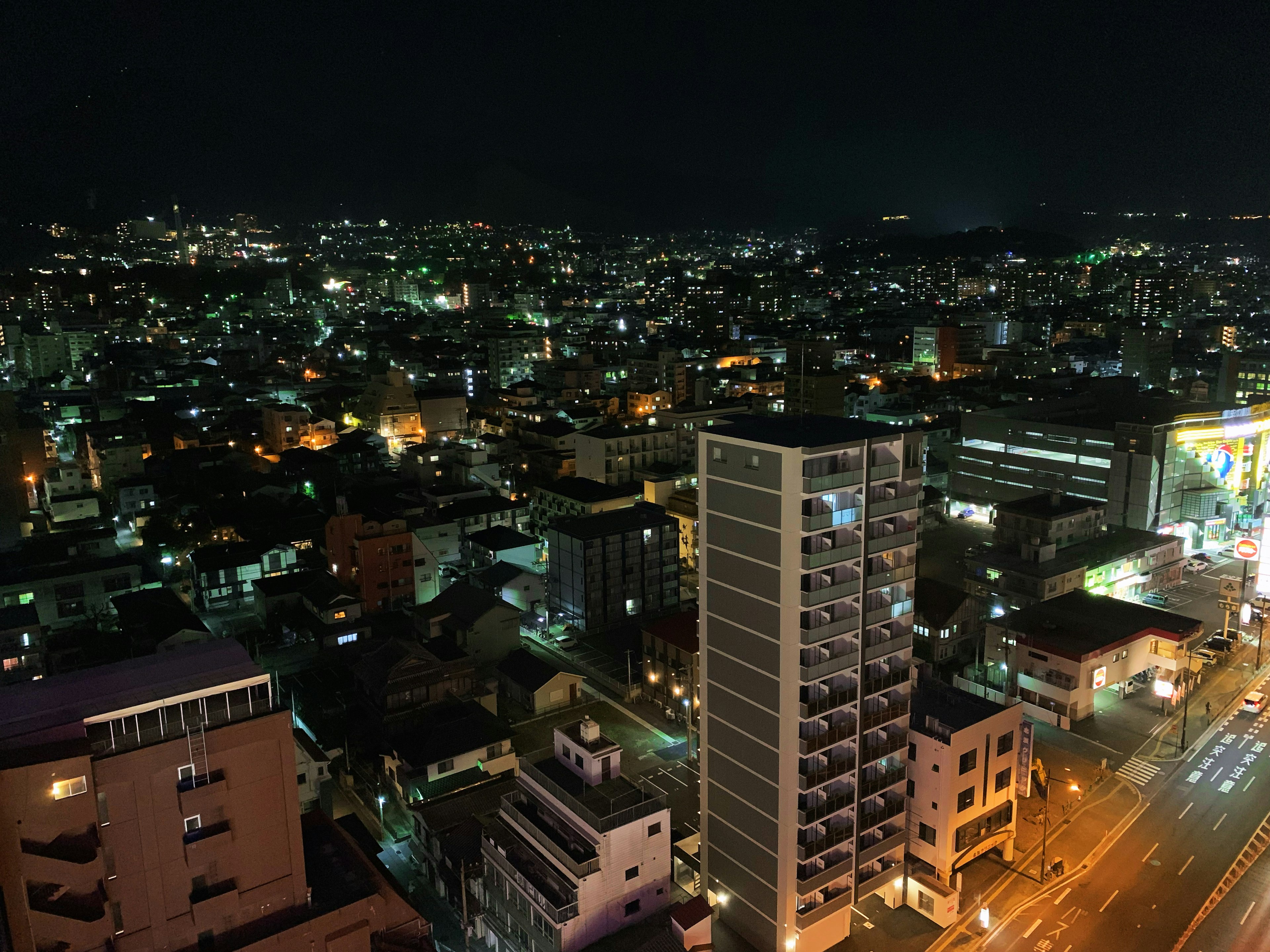 Vista notturna di uno skyline urbano con grattacieli e aree residenziali