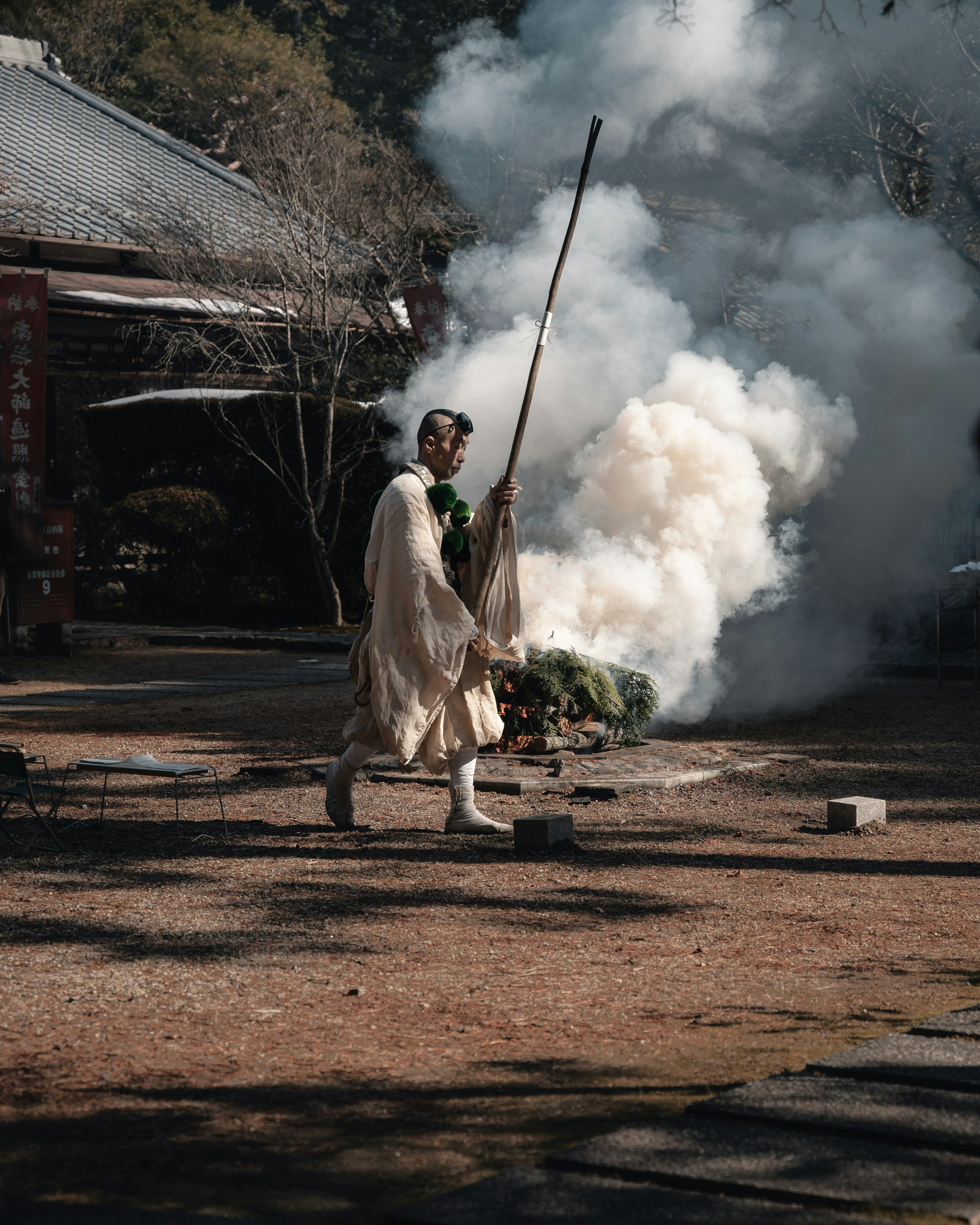 Person in white clothing walking through smoke