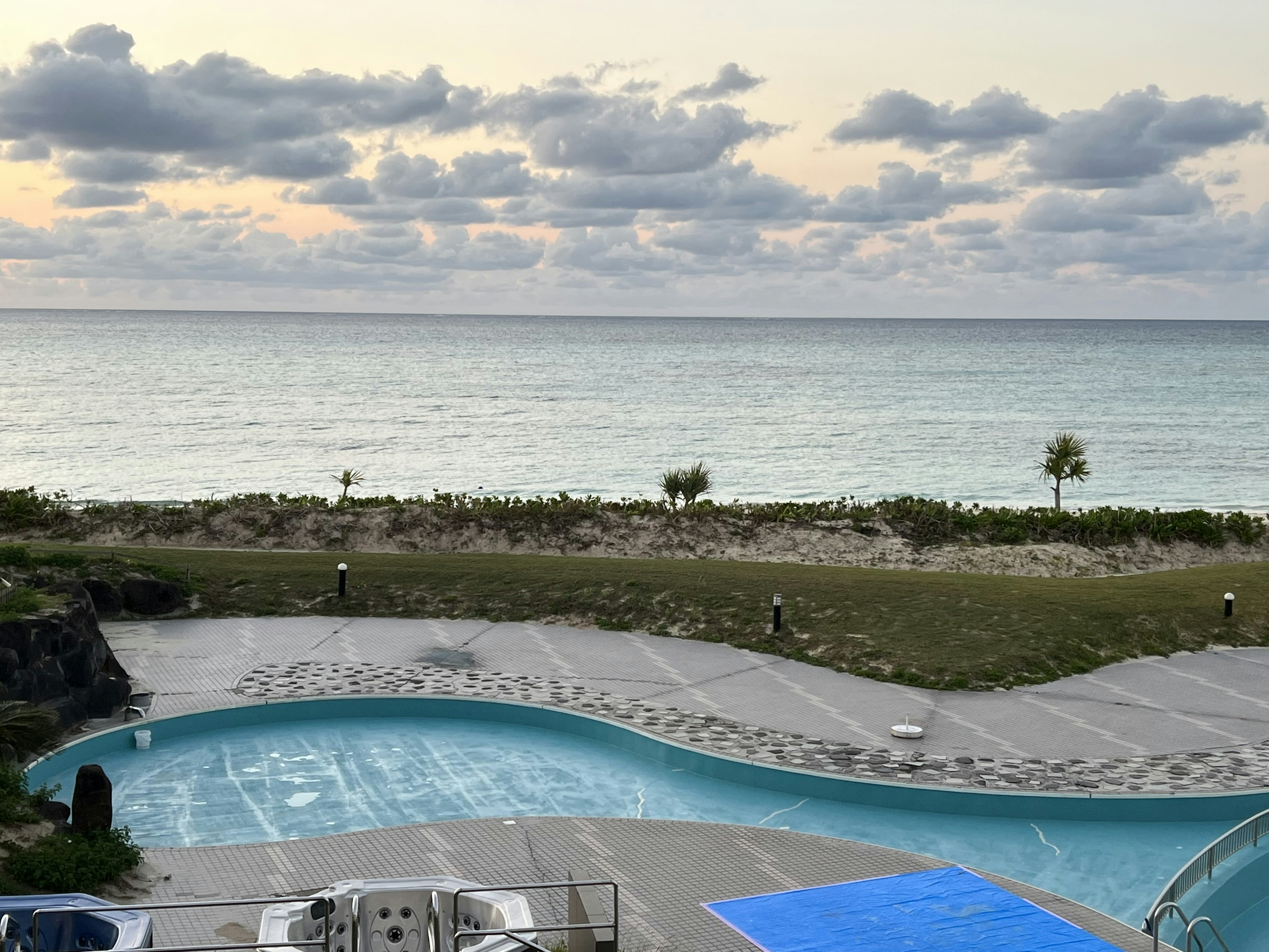 Vista del resort con piscina azul y fondo oceánico