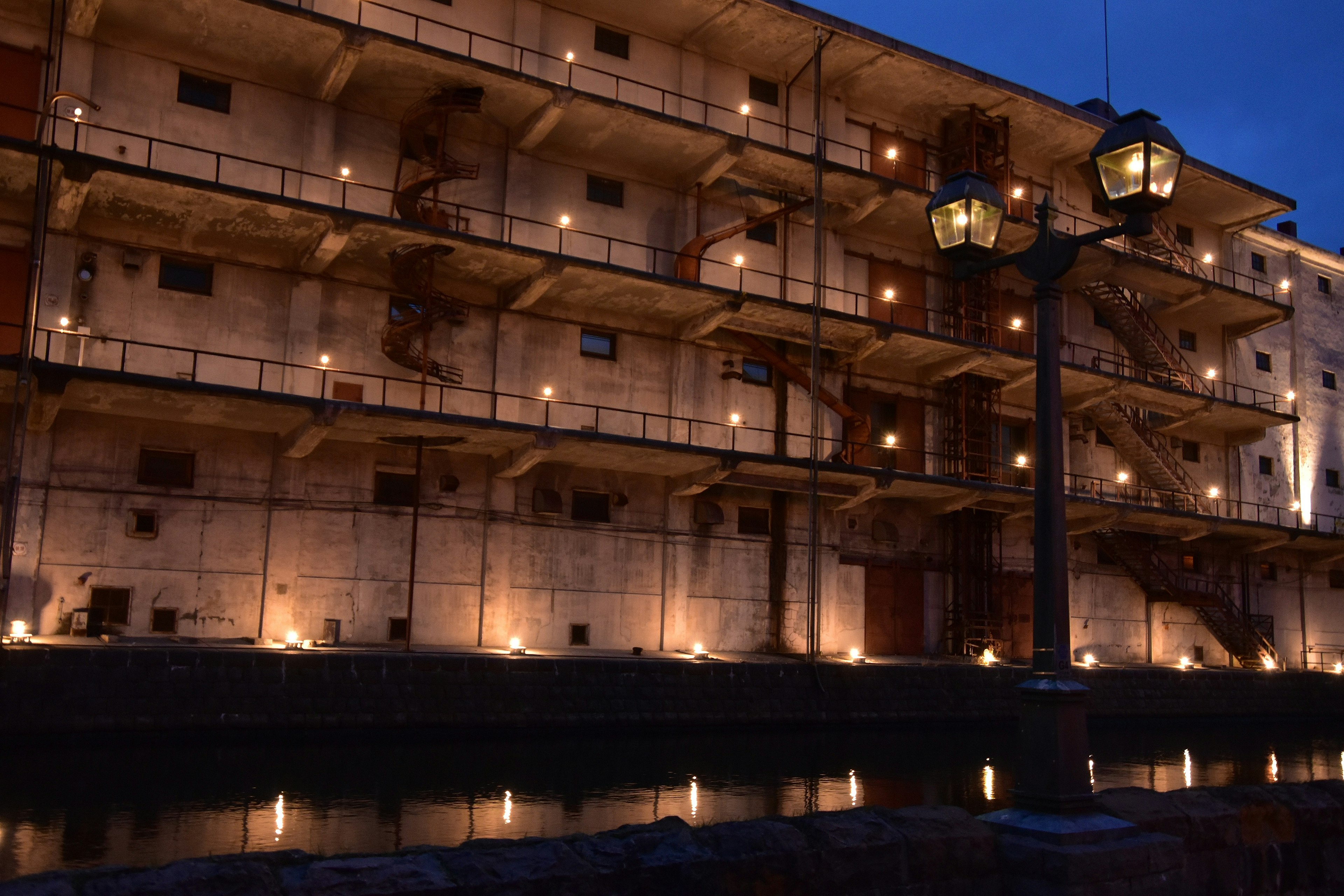 Edificio histórico junto al río iluminado por la noche