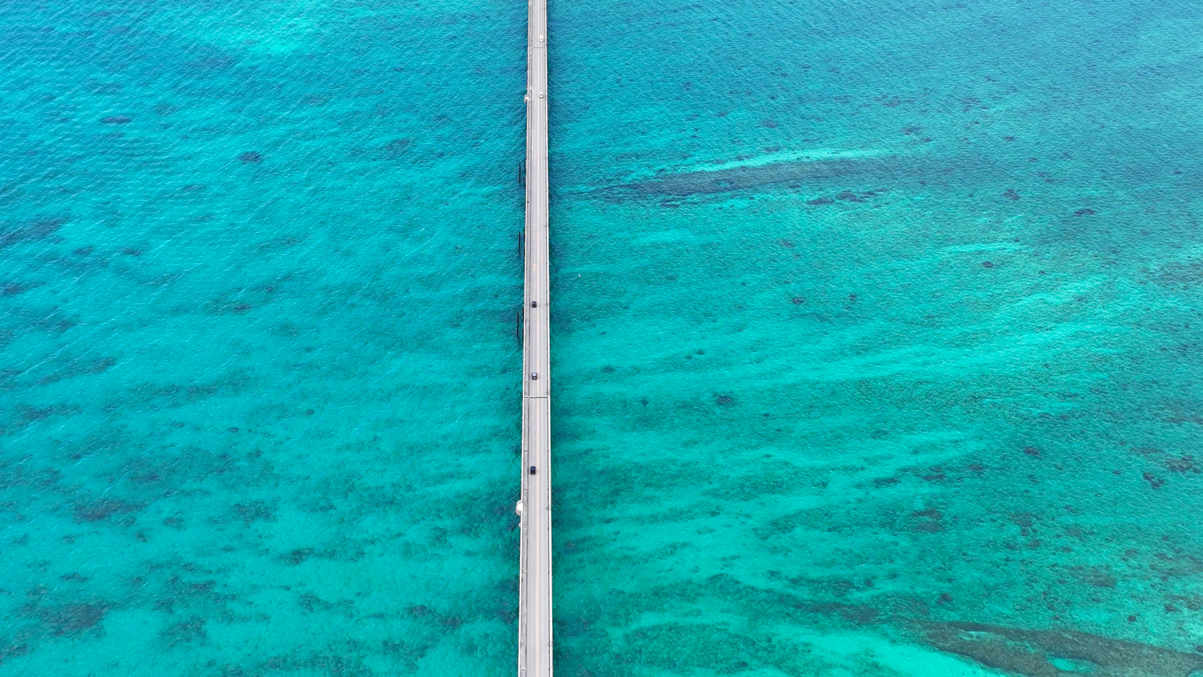 Aerial view of a long white bridge over turquoise water