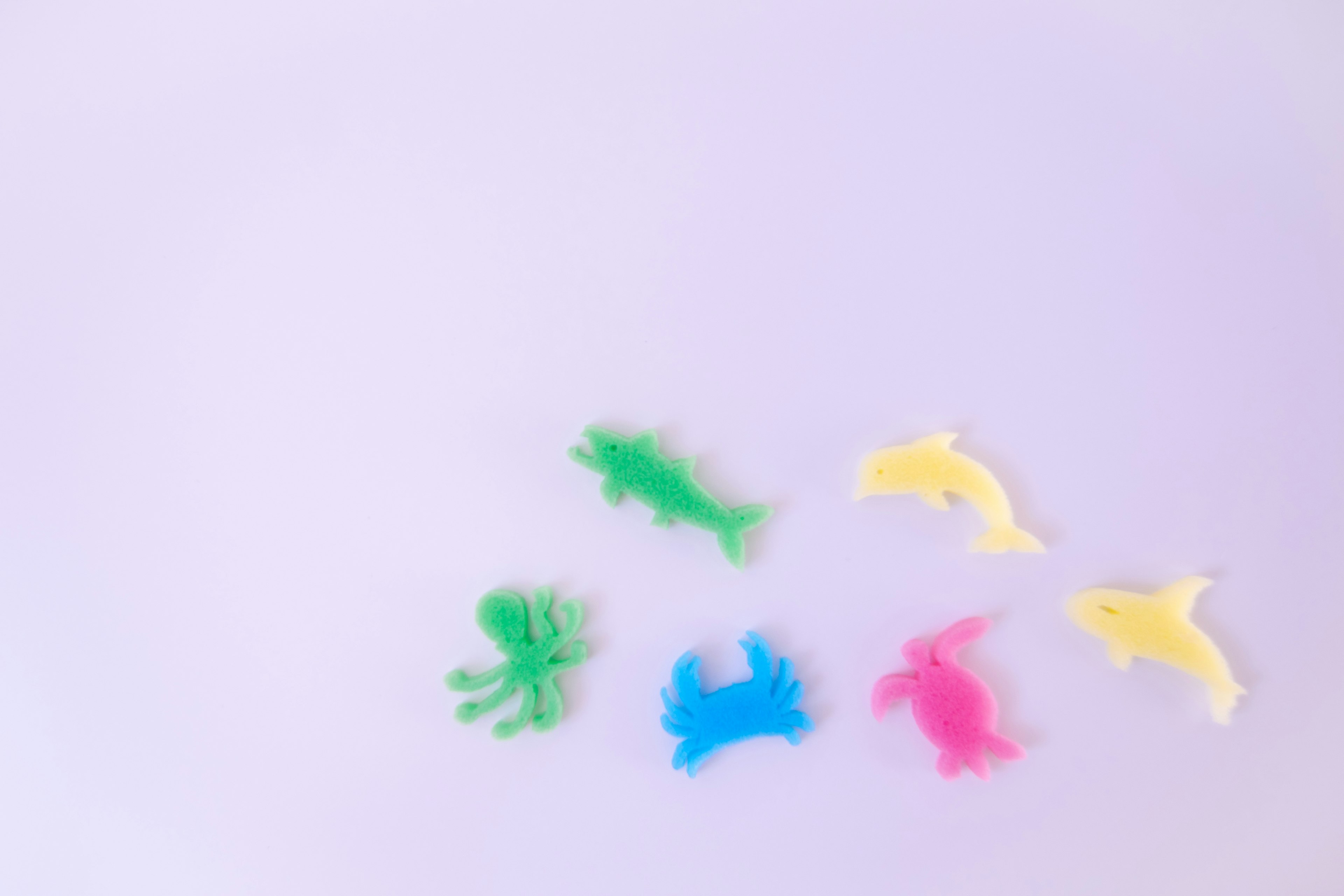 Jouets en plastique colorés représentant des créatures marines disposés sur un fond blanc