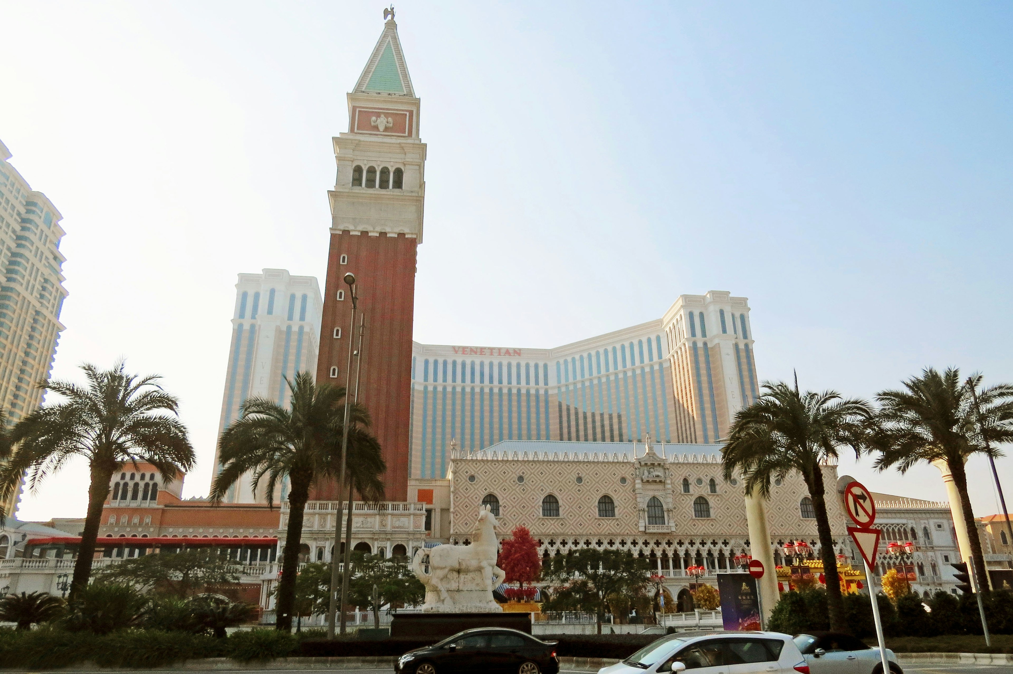 Exterior of the Venetian Hotel featuring a tall tower and palm trees