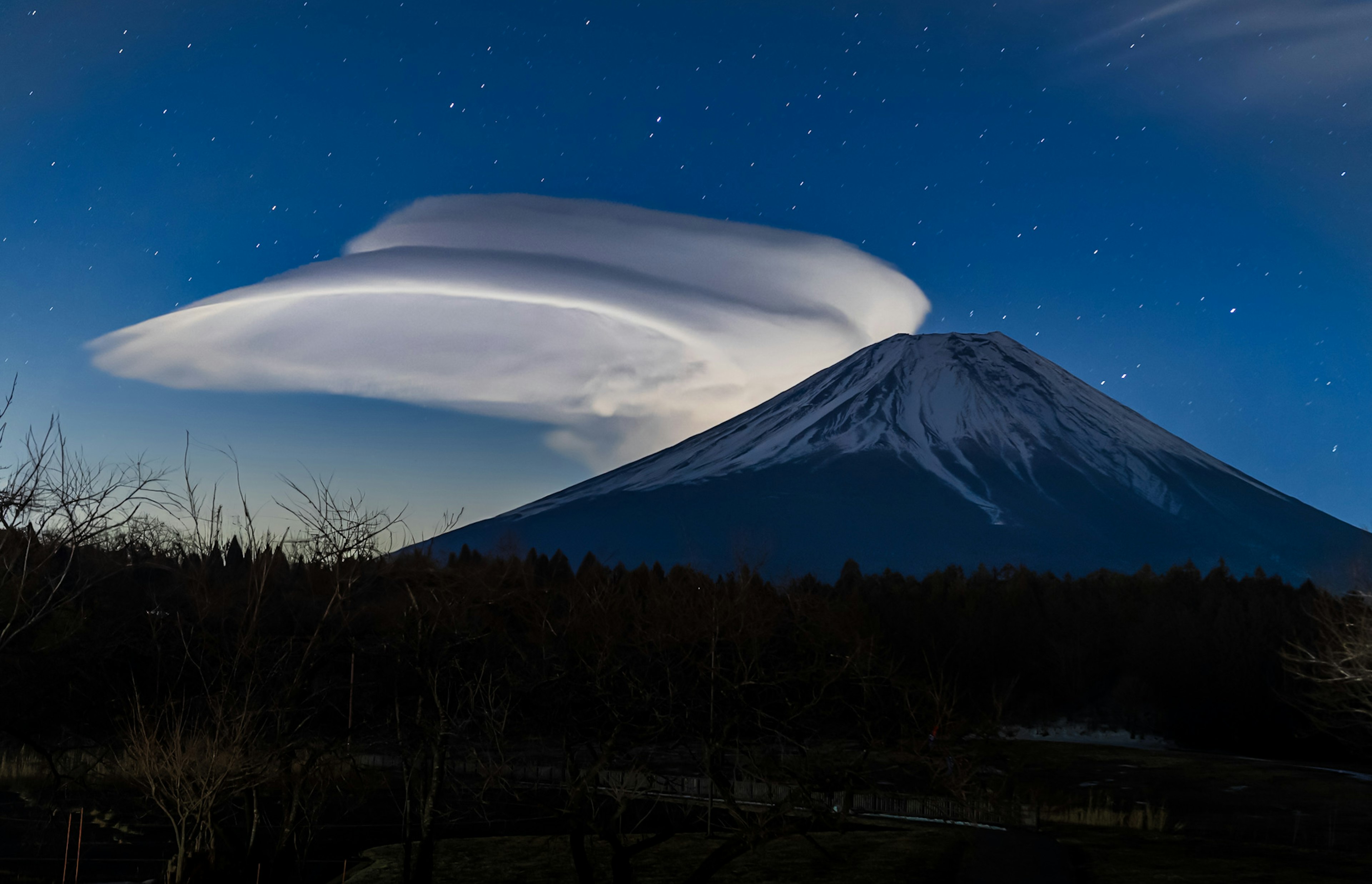 Monte Fuji con una nube lenticular única en un cielo estrellado