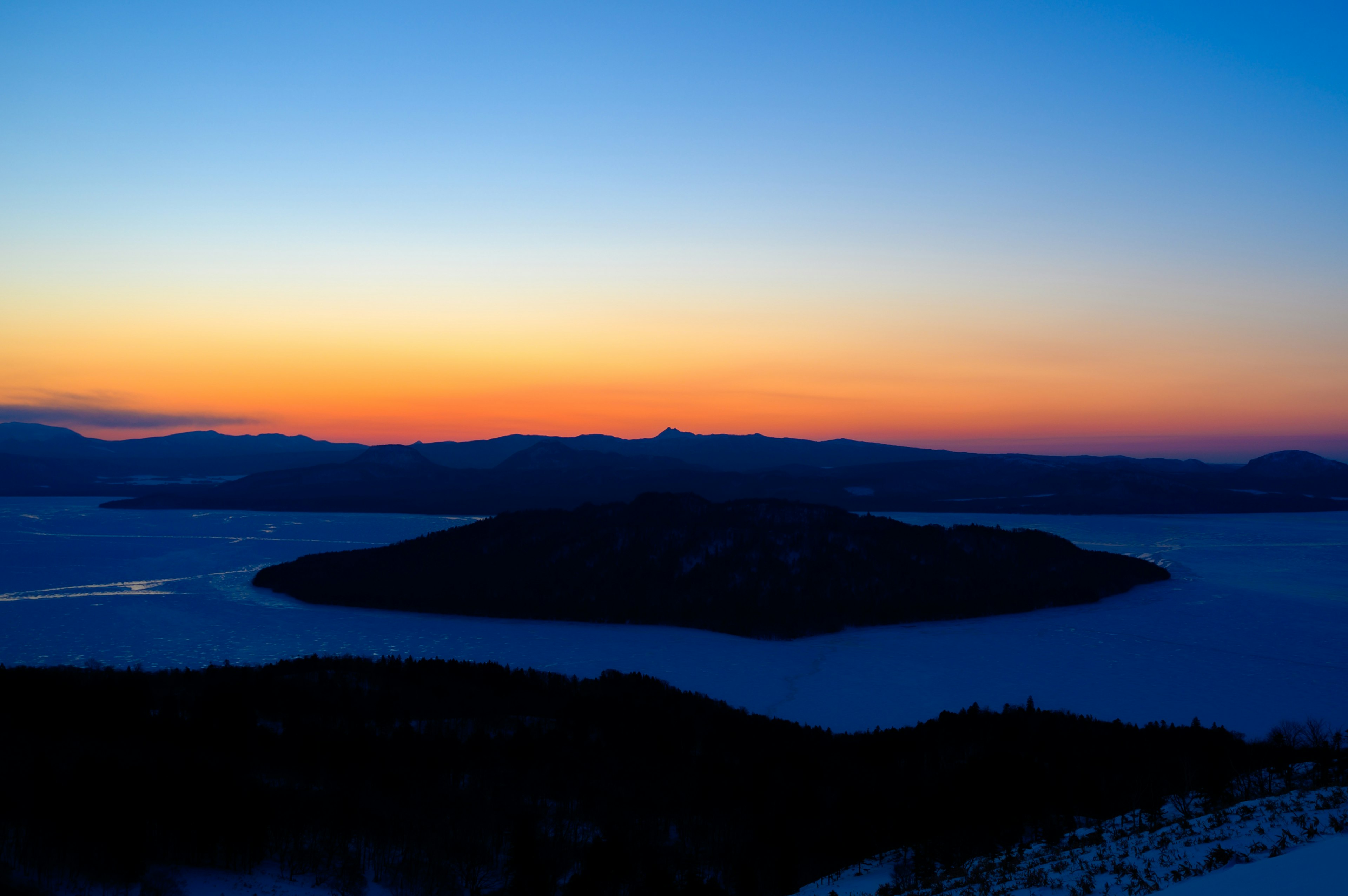 雪に覆われた島と青い空の夕焼け