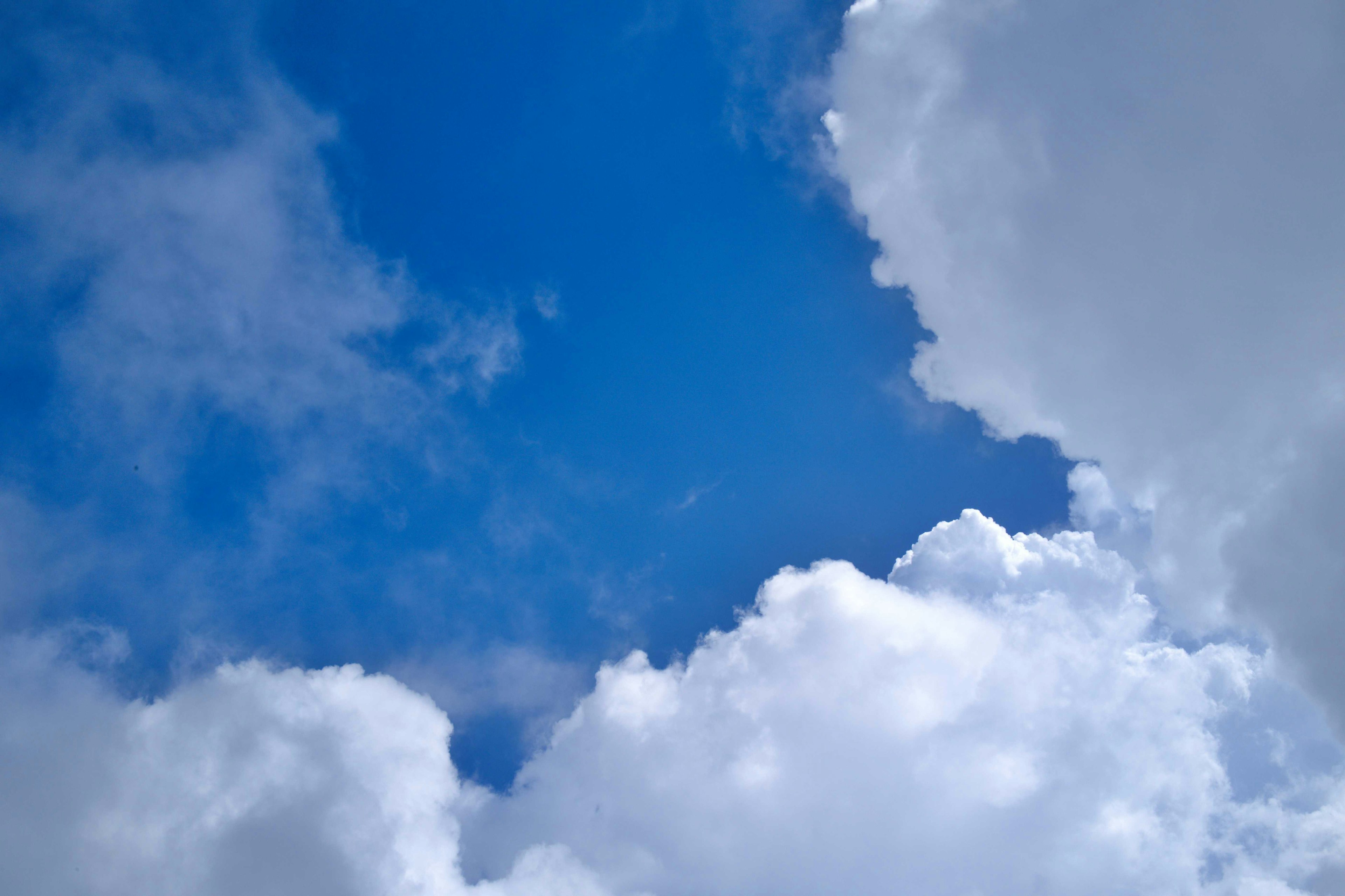 Ein klarer blauer Himmel mit flauschigen weißen Wolken