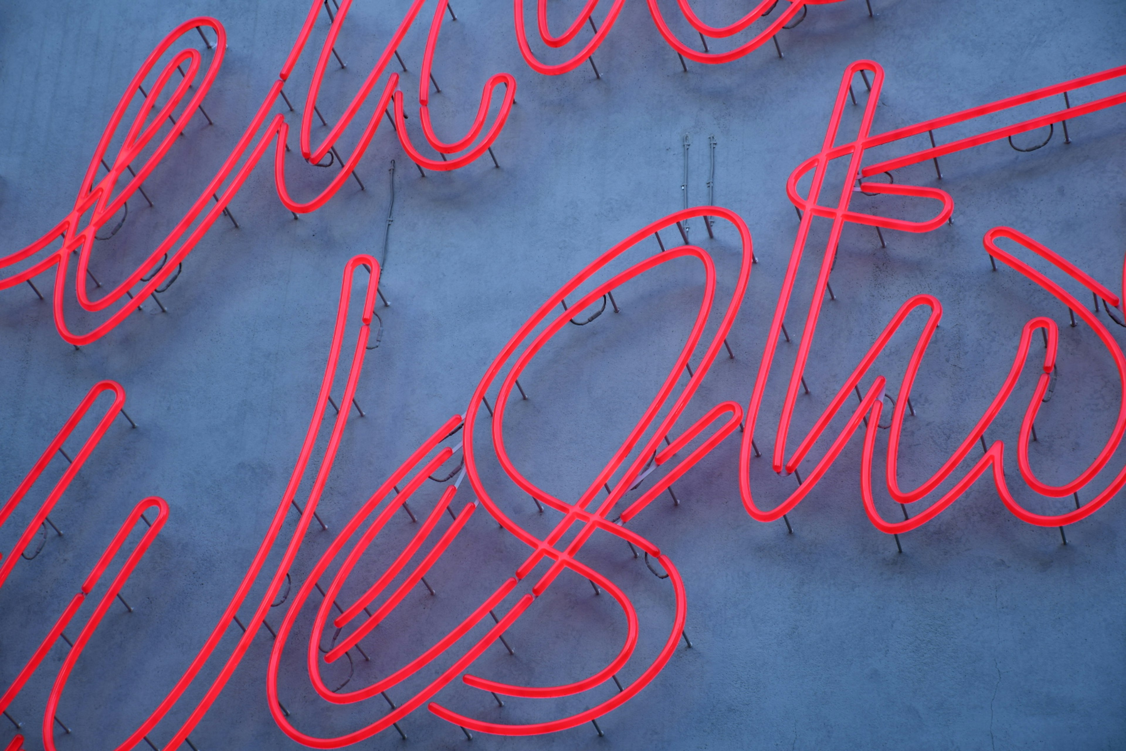 Immagine di lettere al neon rosse che scrivono 'Ovest' su uno sfondo blu