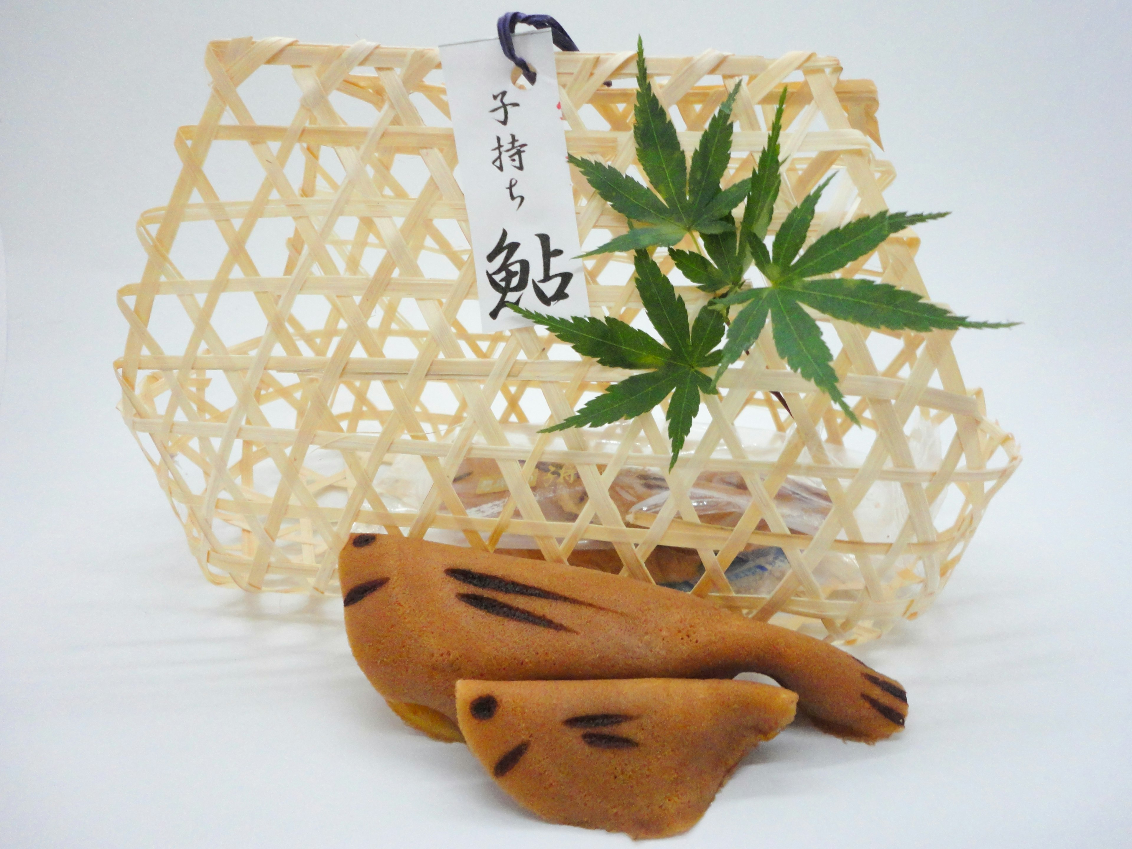 A delicate traditional basket with green leaves and decorative sweets