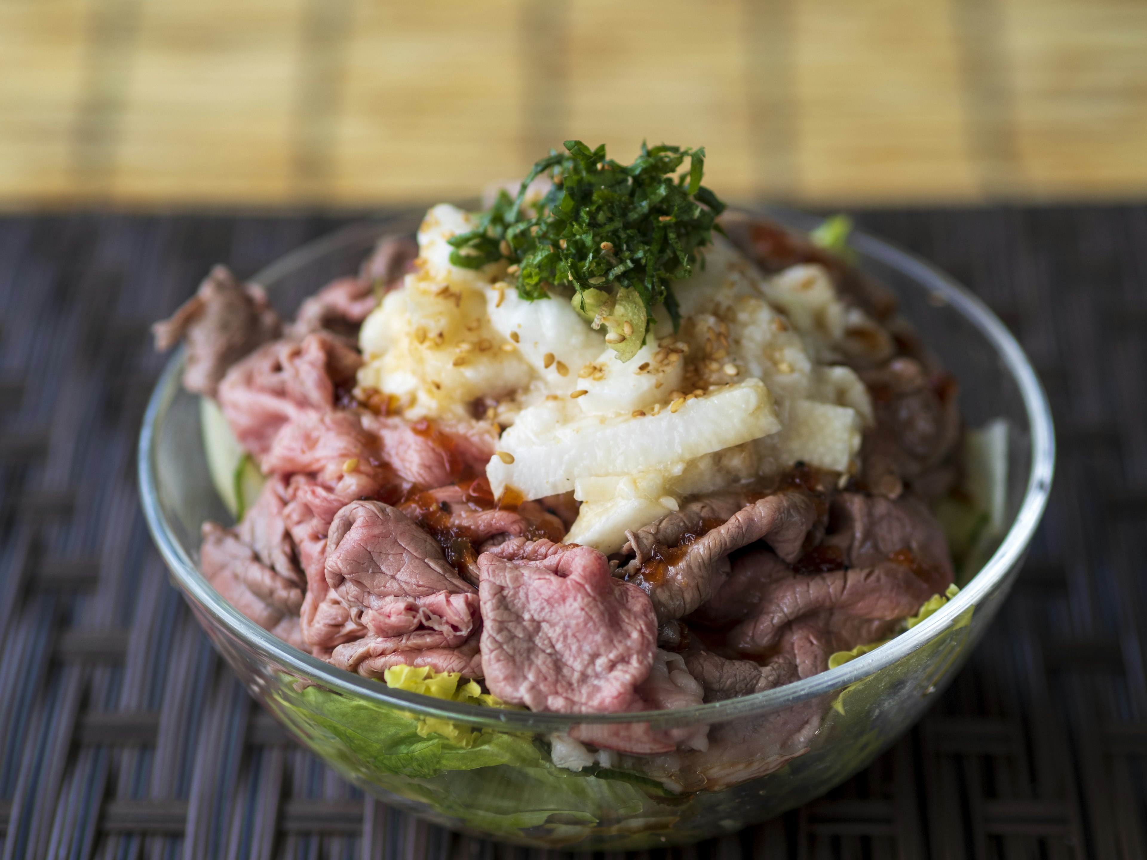 Bol de viande tranchée garni de radis râpé et d'oignons verts