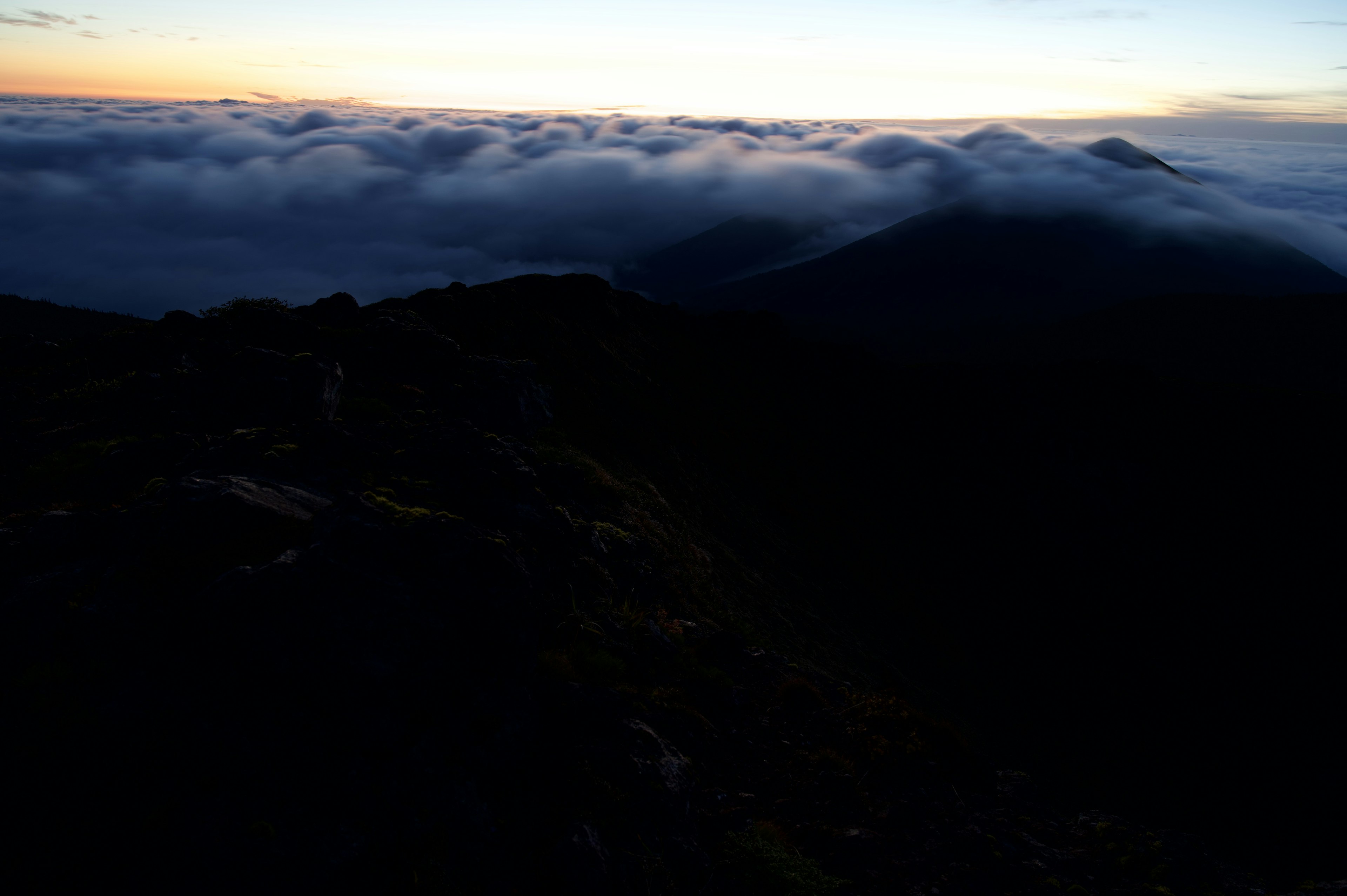 Vista di un mare di nuvole al tramonto da un picco montano