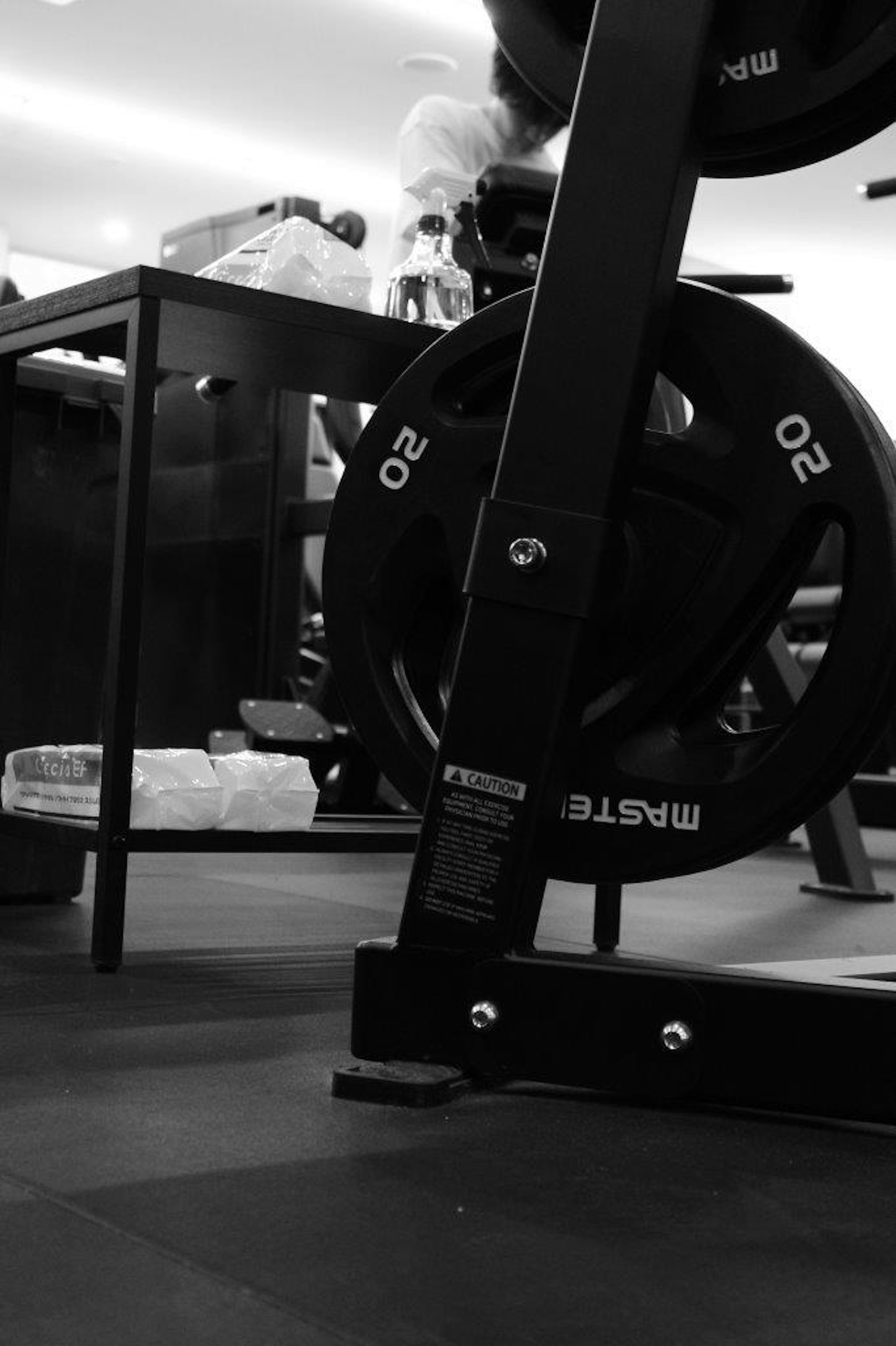 Image en noir et blanc d'équipement de gym avec des poids et un banc d'entraînement