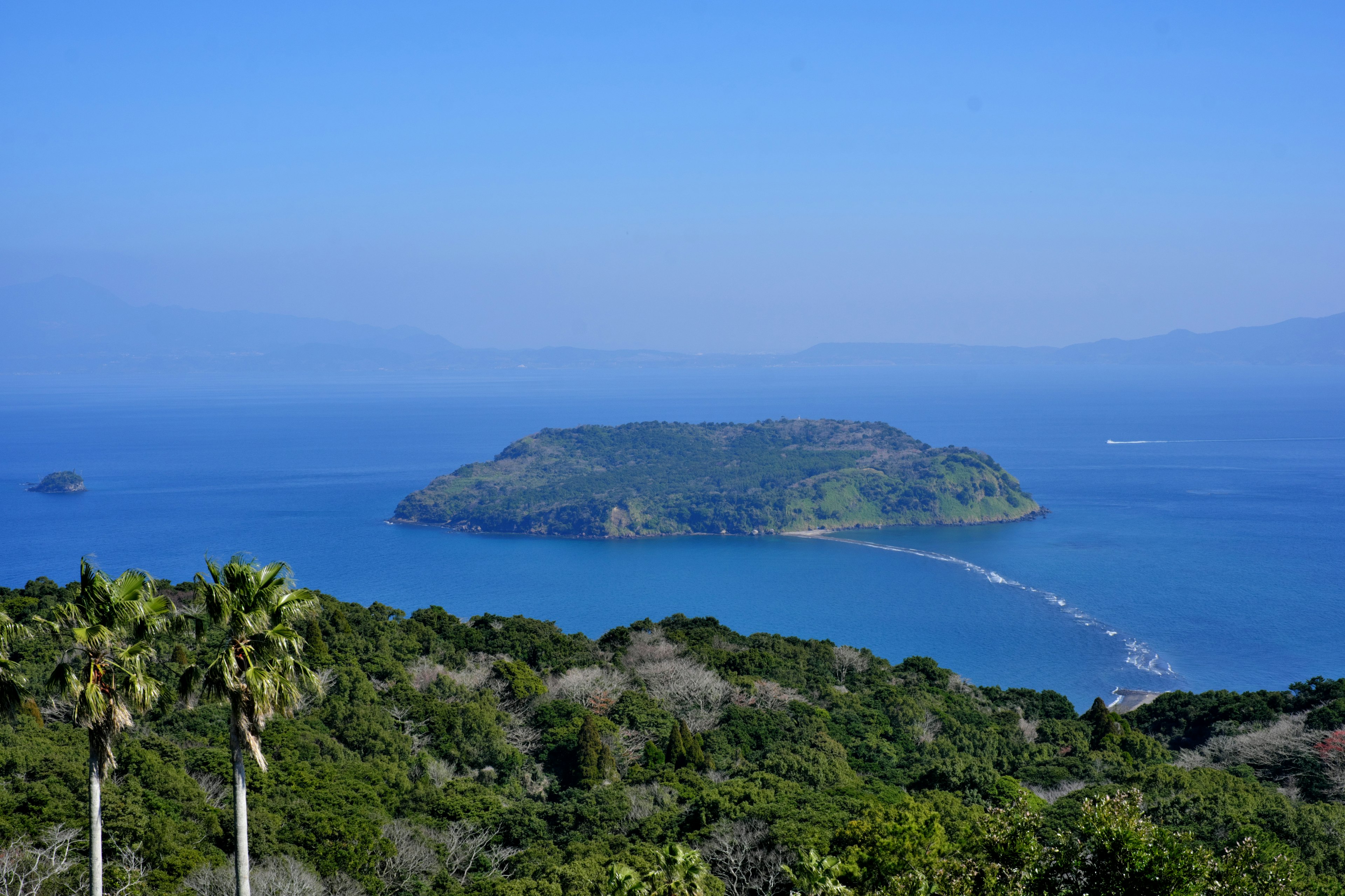 Pemandangan indah pulau hijau dikelilingi air biru