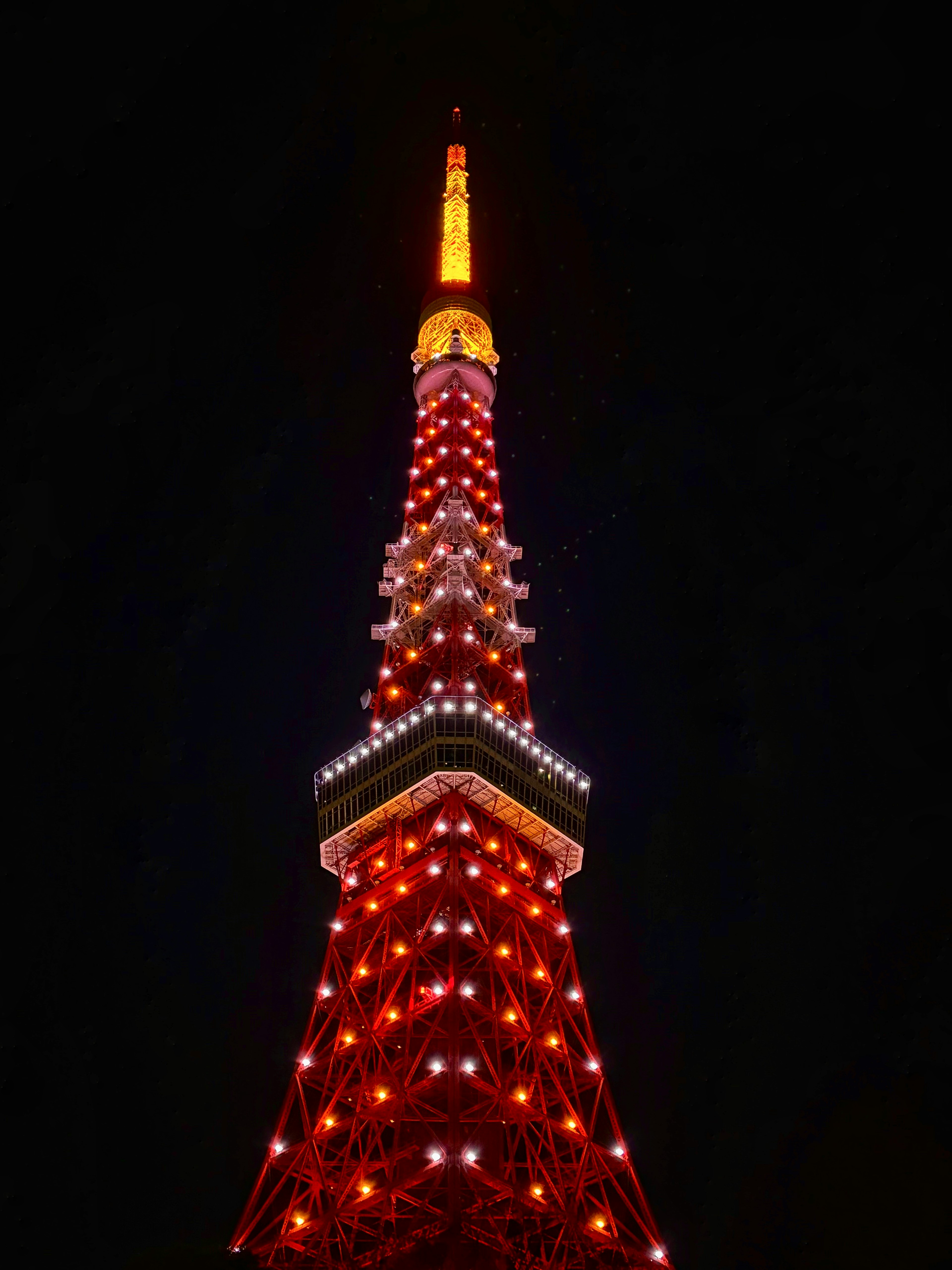 Tokio Tower bei Nacht beleuchtet mit roten und orangefarbenen Lichtern