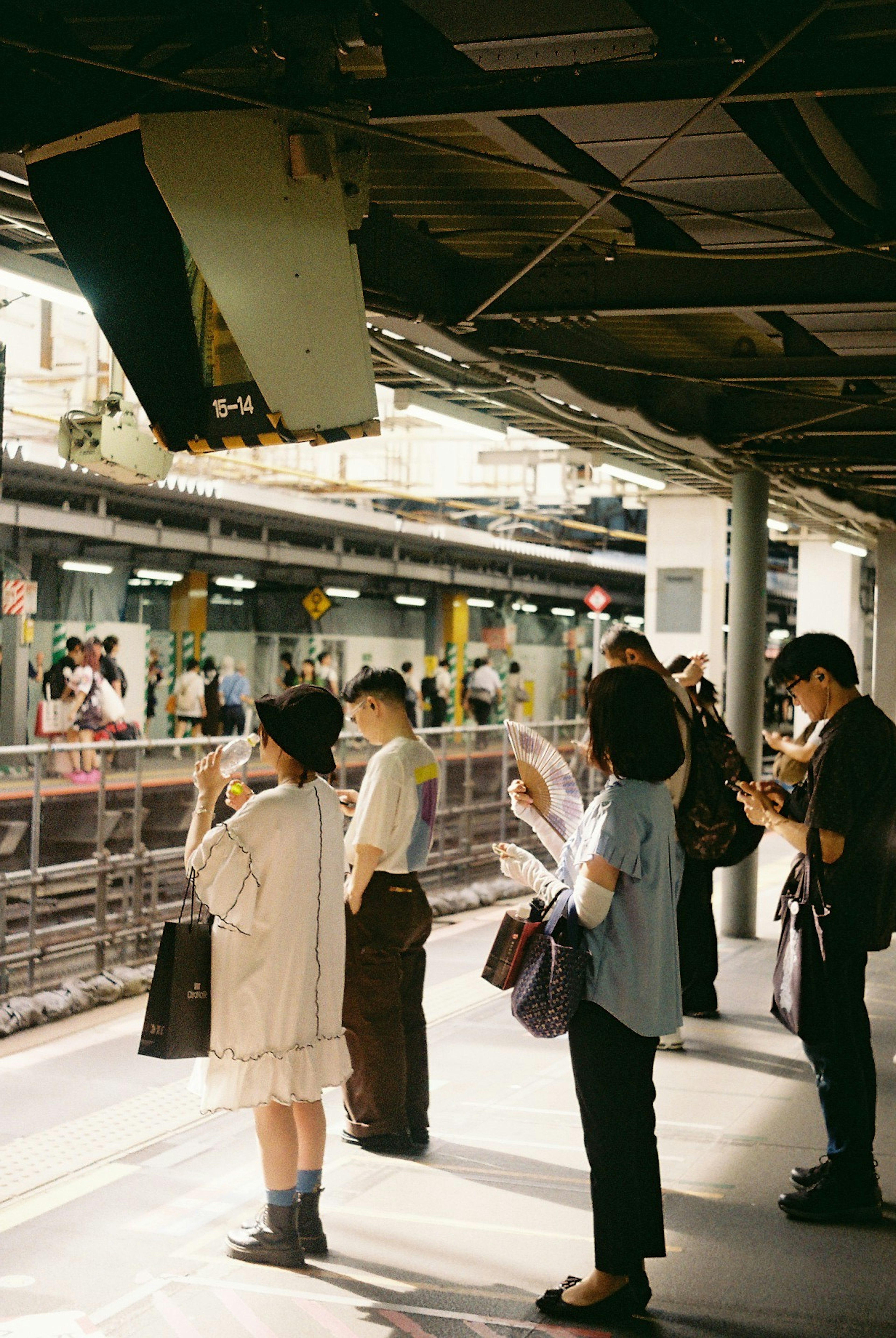 駅のプラットフォームで待つ人々の様子