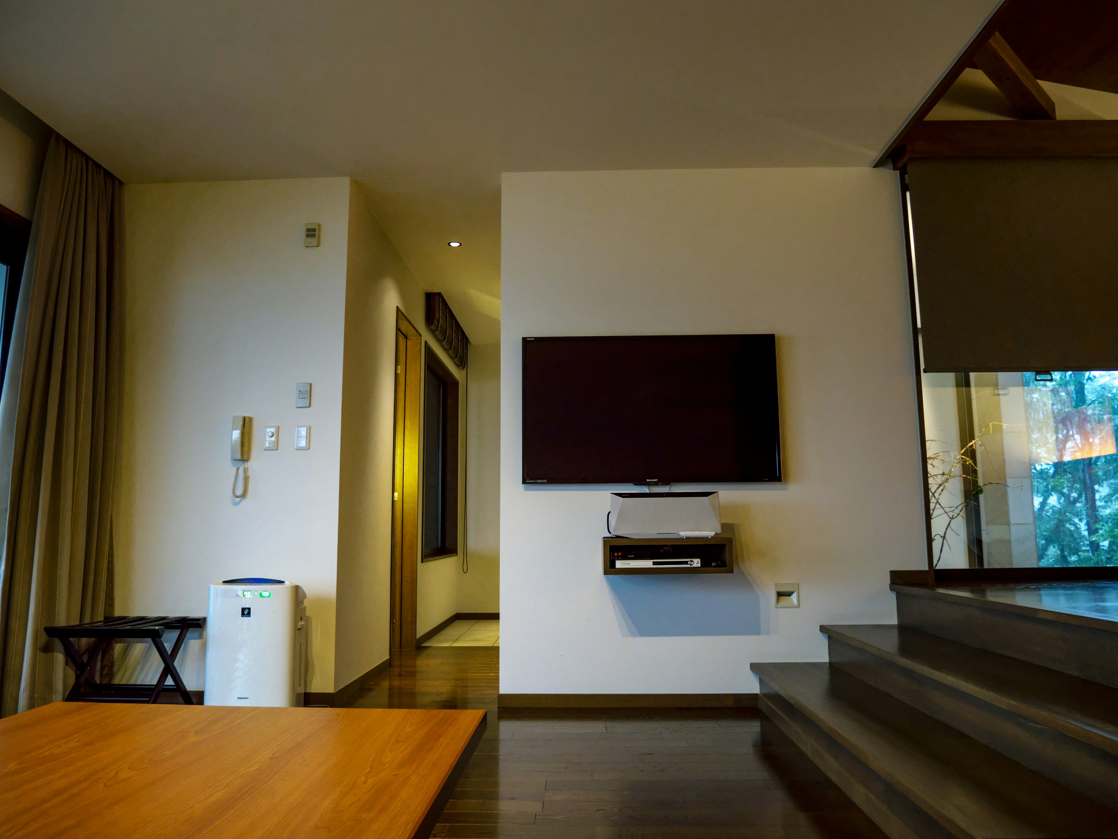 Modern living room interior with wall-mounted TV and wooden table