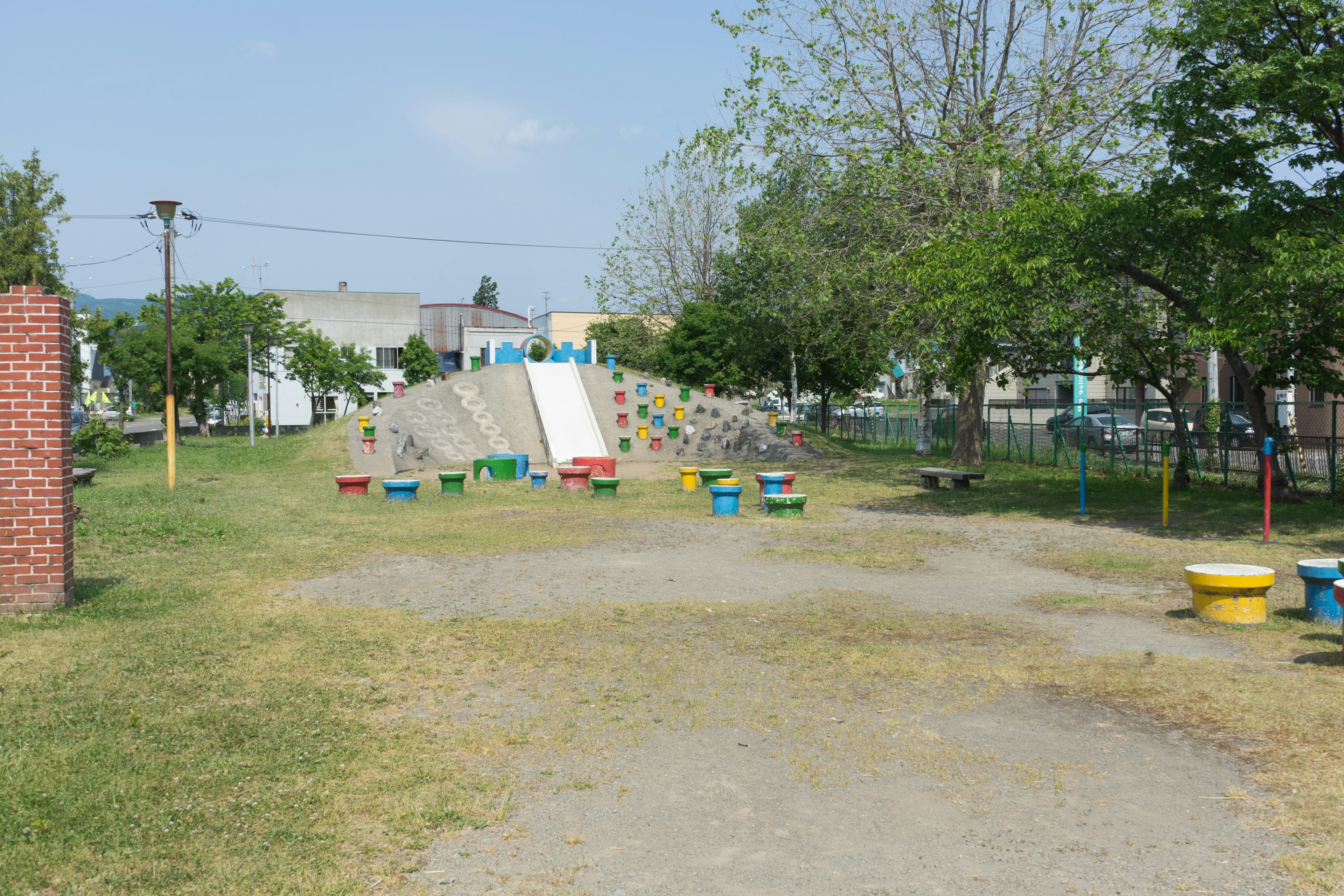 Vue d'un parc avec des équipements de jeux colorés et des arbres verts