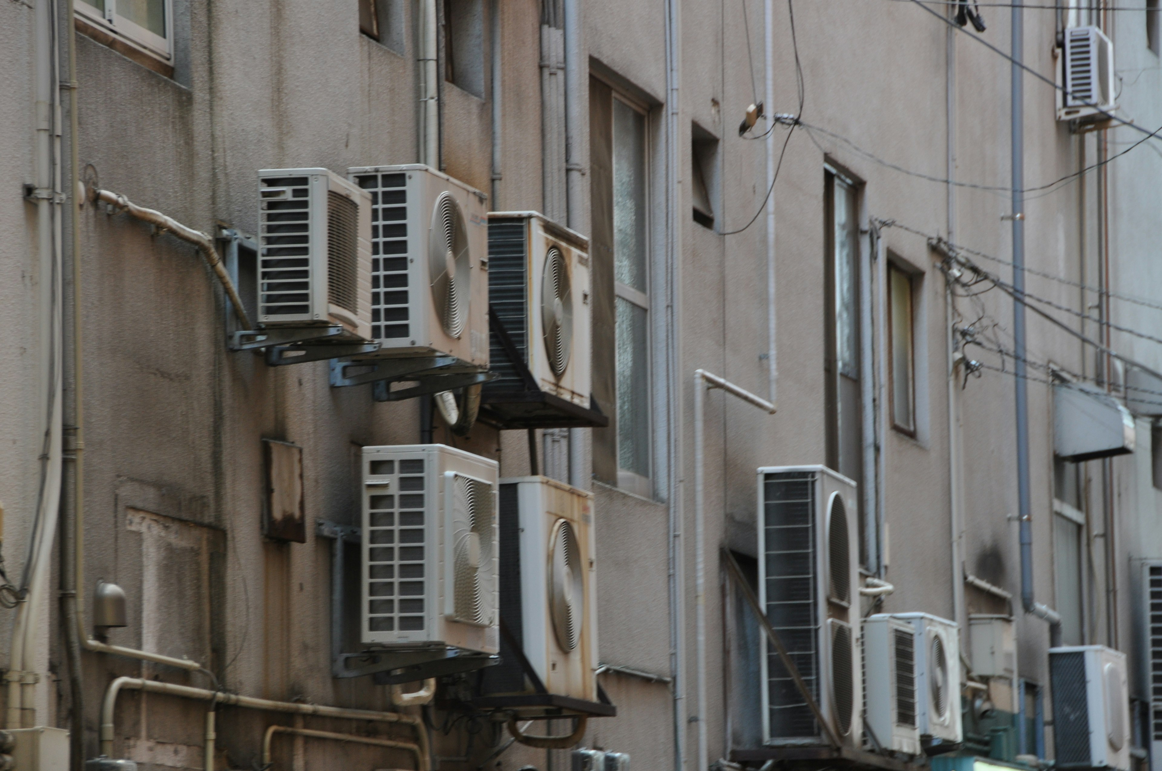 Multiple air conditioning units mounted on a building's exterior wall