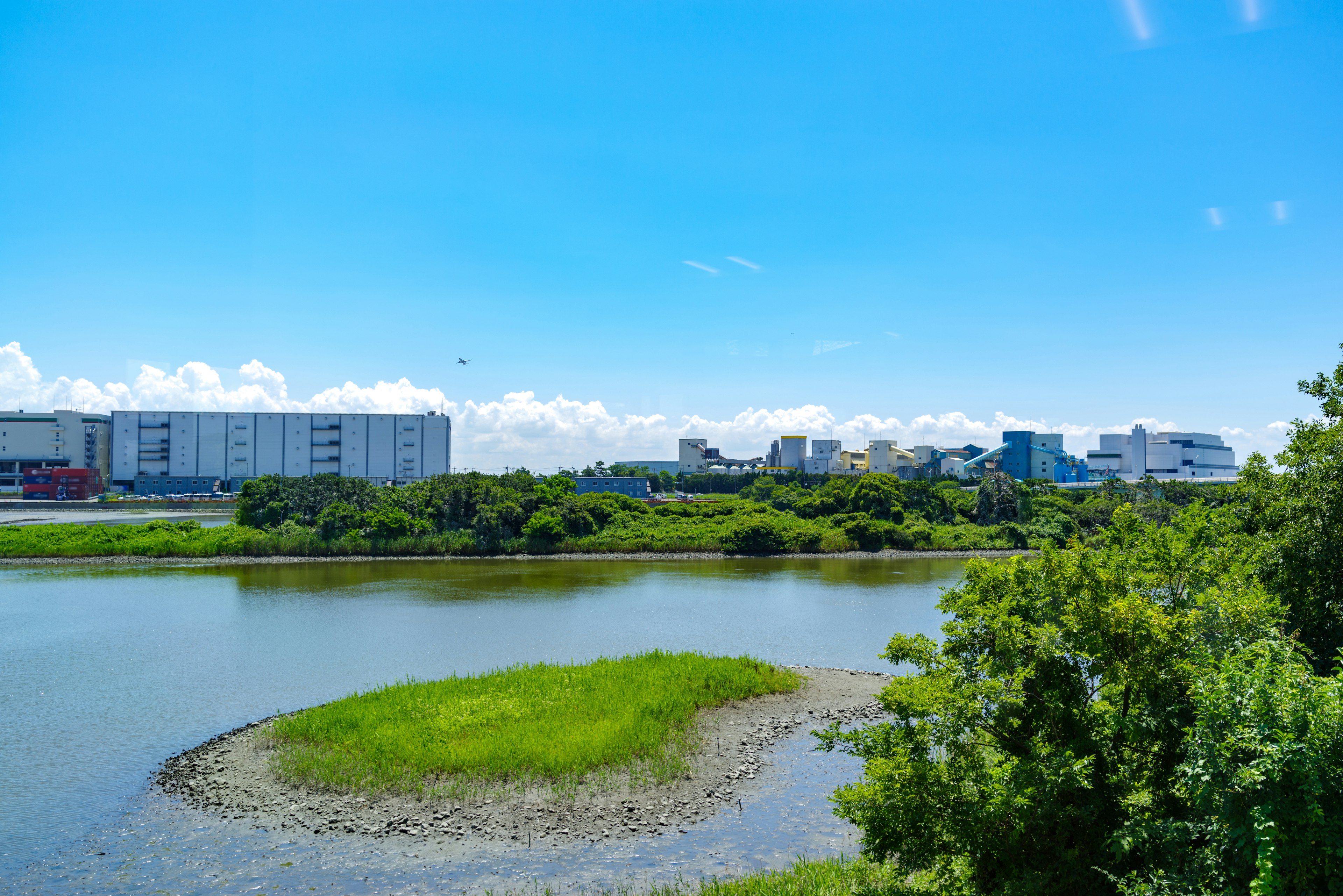 Scenic view of a river with a green island under a blue sky