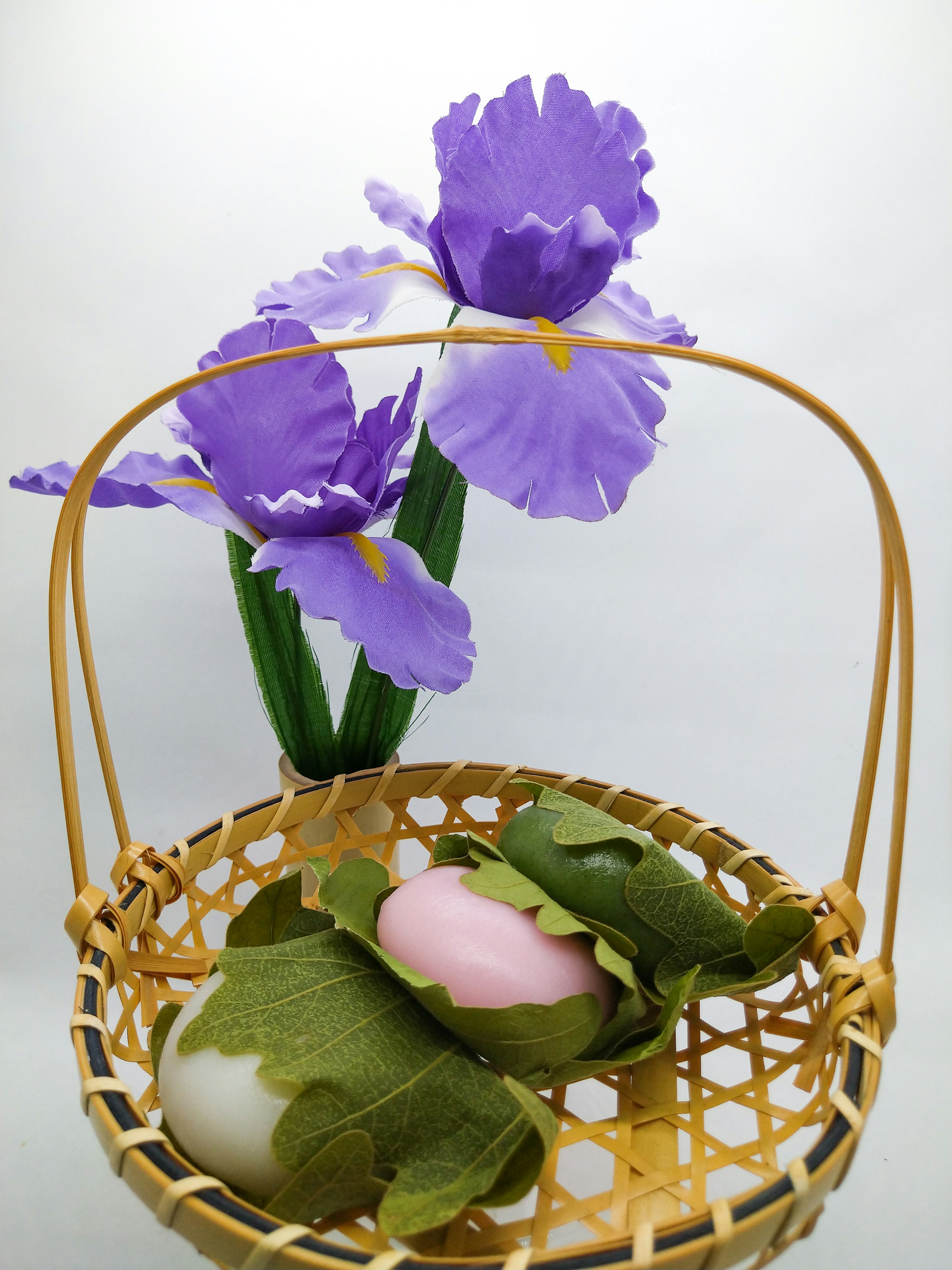 A basket with purple flowers and traditional Japanese sweets