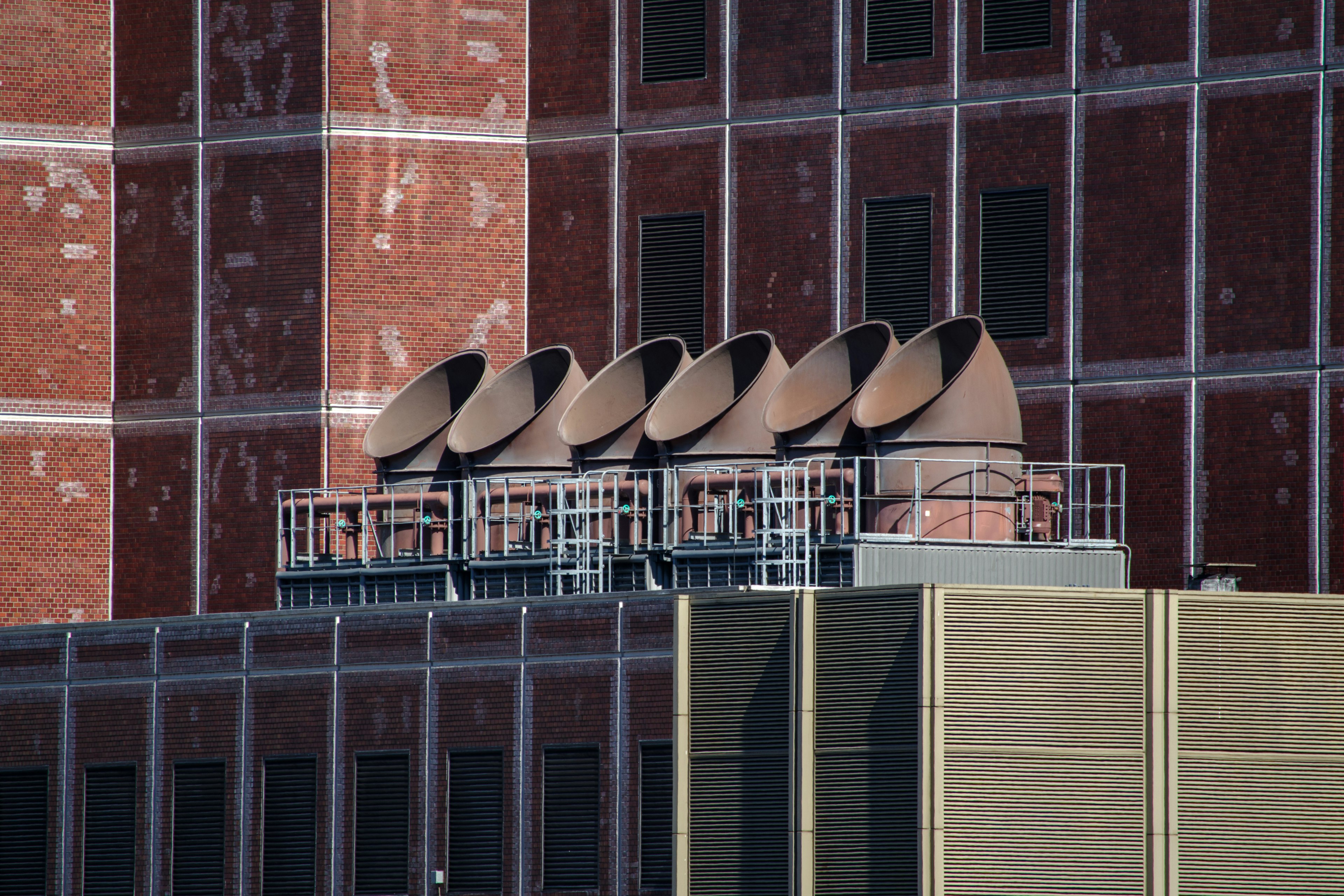 Ductos de metal dispuestos en la parte superior de un edificio de ladrillo rojo