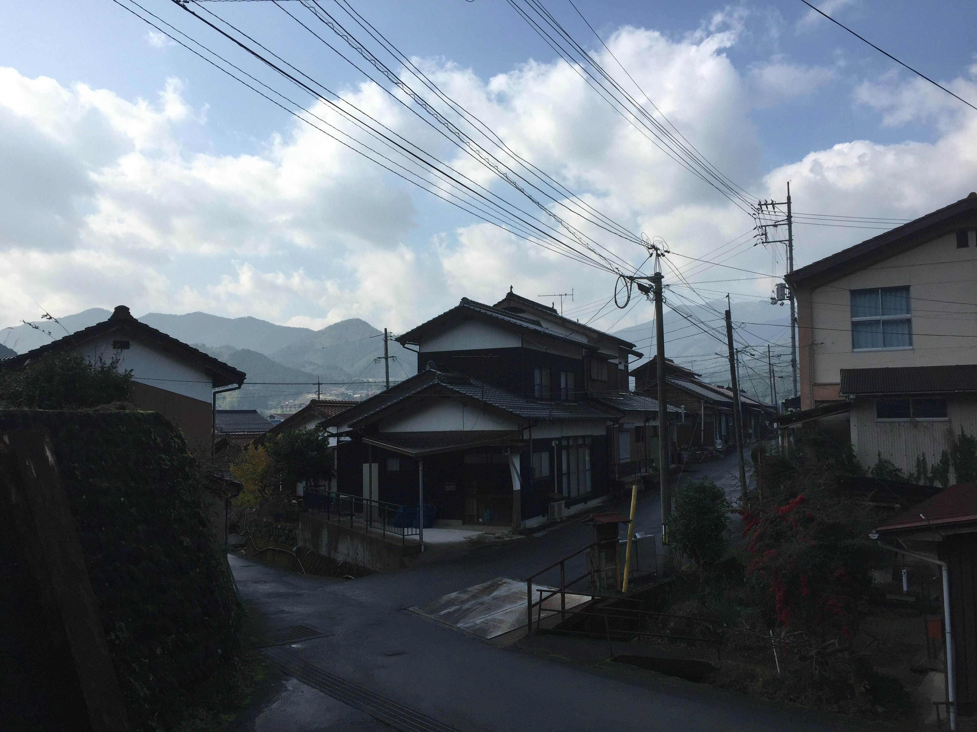 Quiet Japanese residential street with houses and mountains in the background