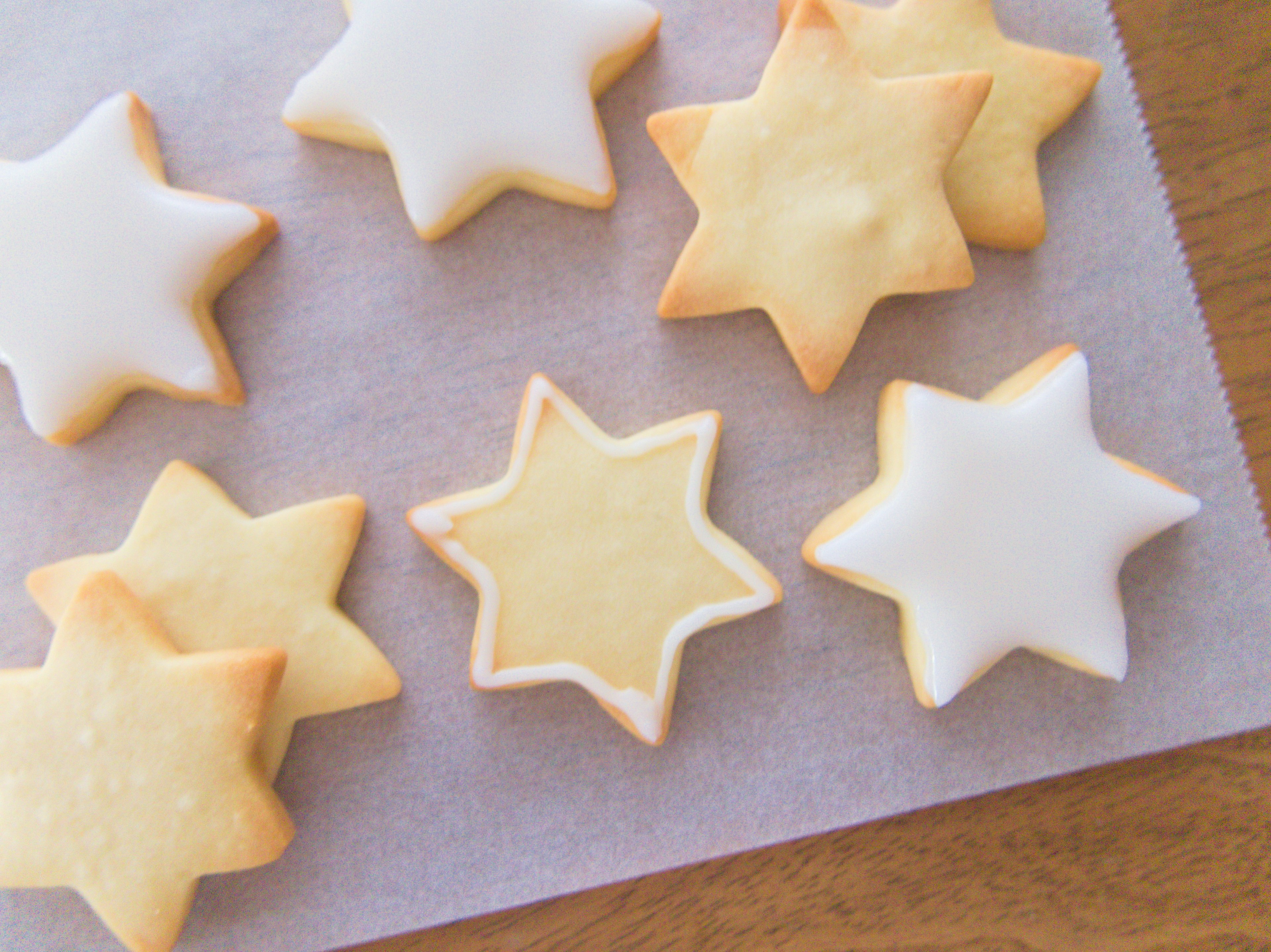 Gambar kue berbentuk bintang dengan beberapa dihias dengan icing putih