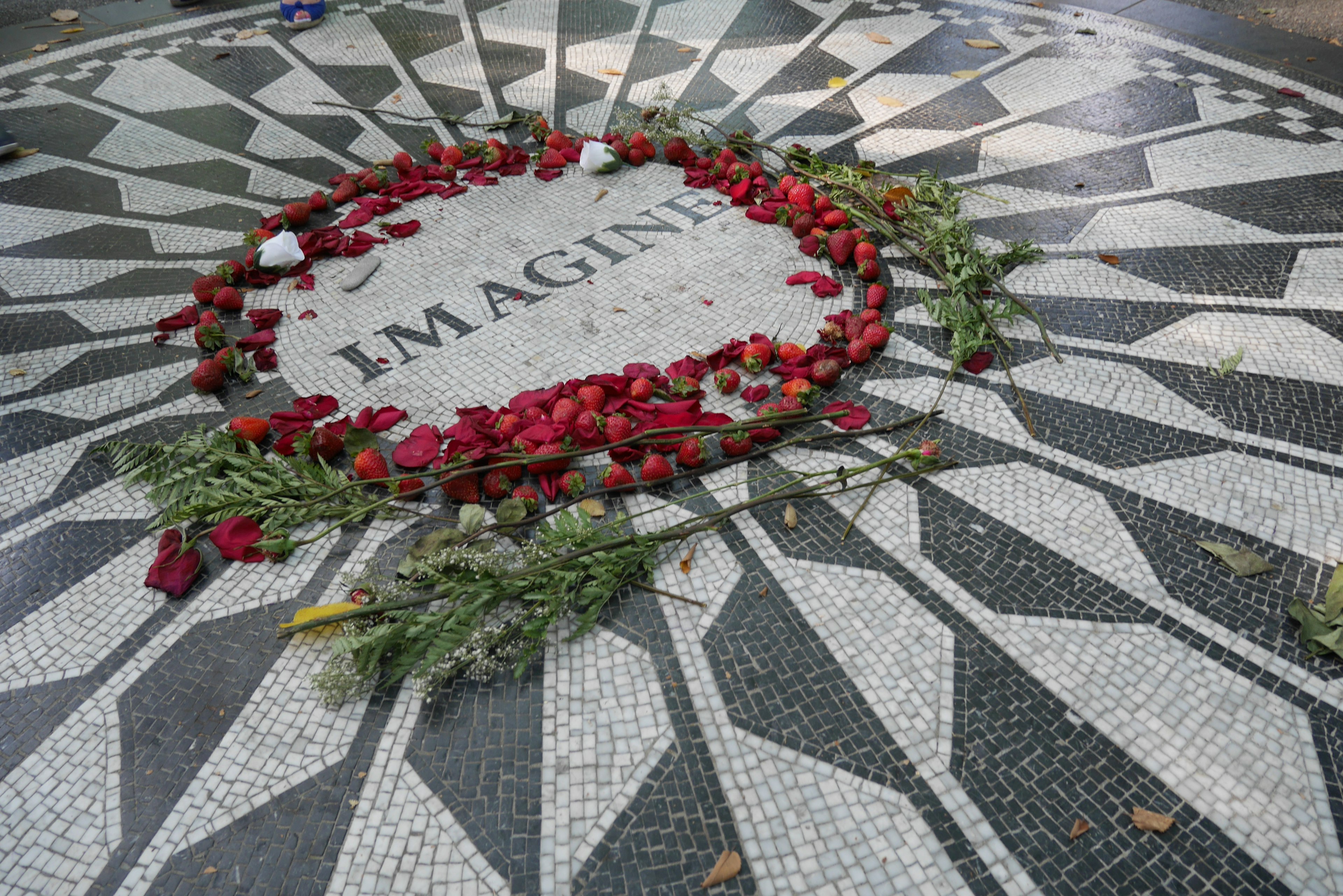 Mosaic floor with the word IMAGINE surrounded by red roses and green leaves