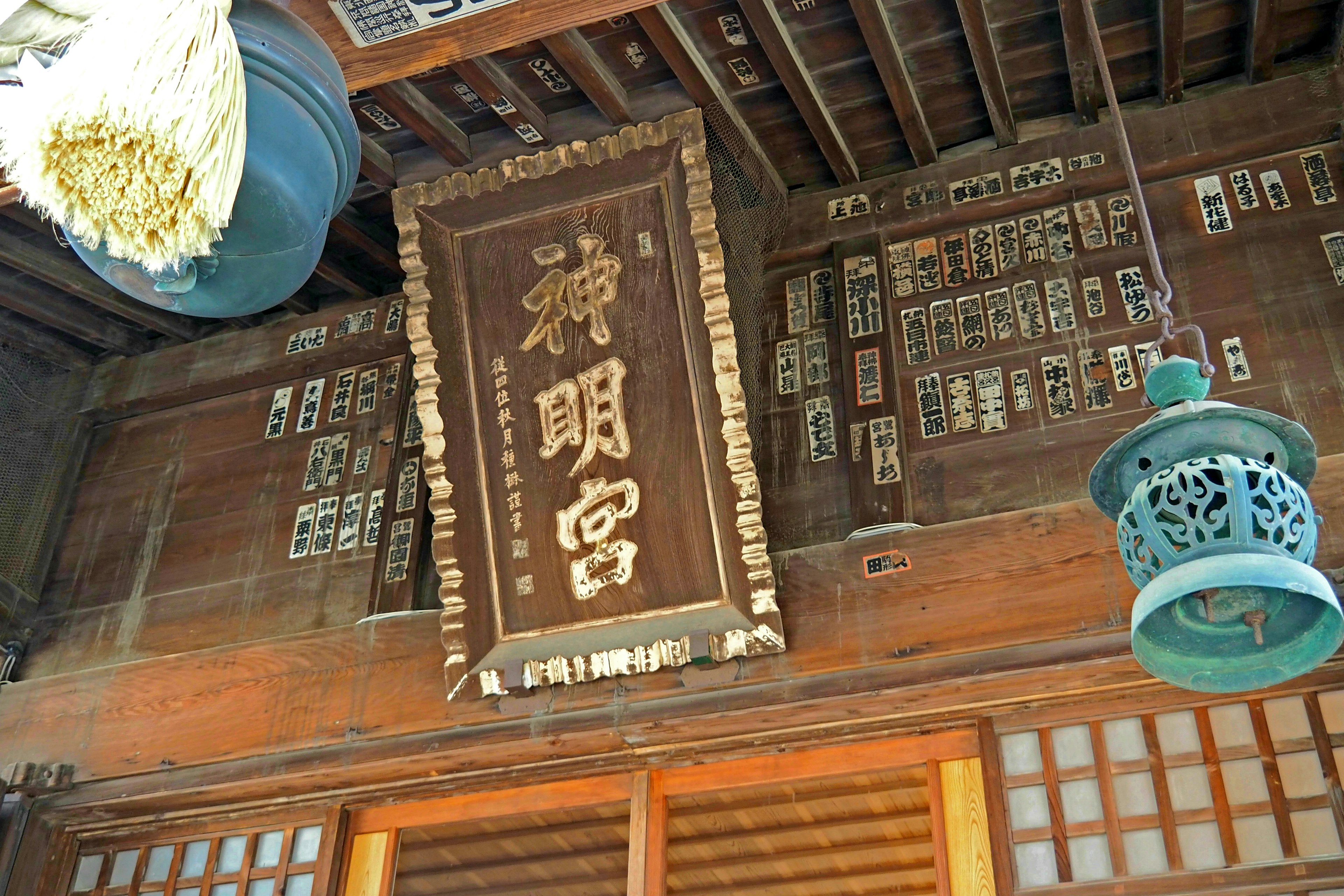 Interior of traditional Japanese architecture featuring decorative lantern and ancient sign