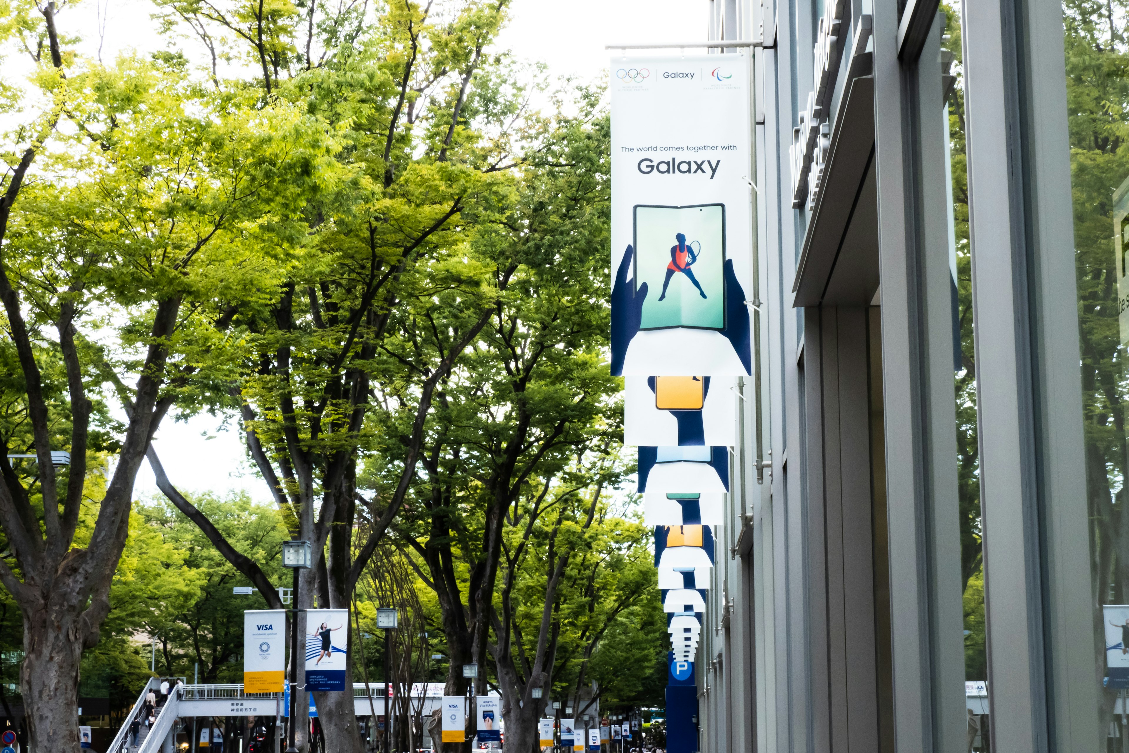 Exterior de un edificio con un anuncio de Galaxy entre árboles verdes