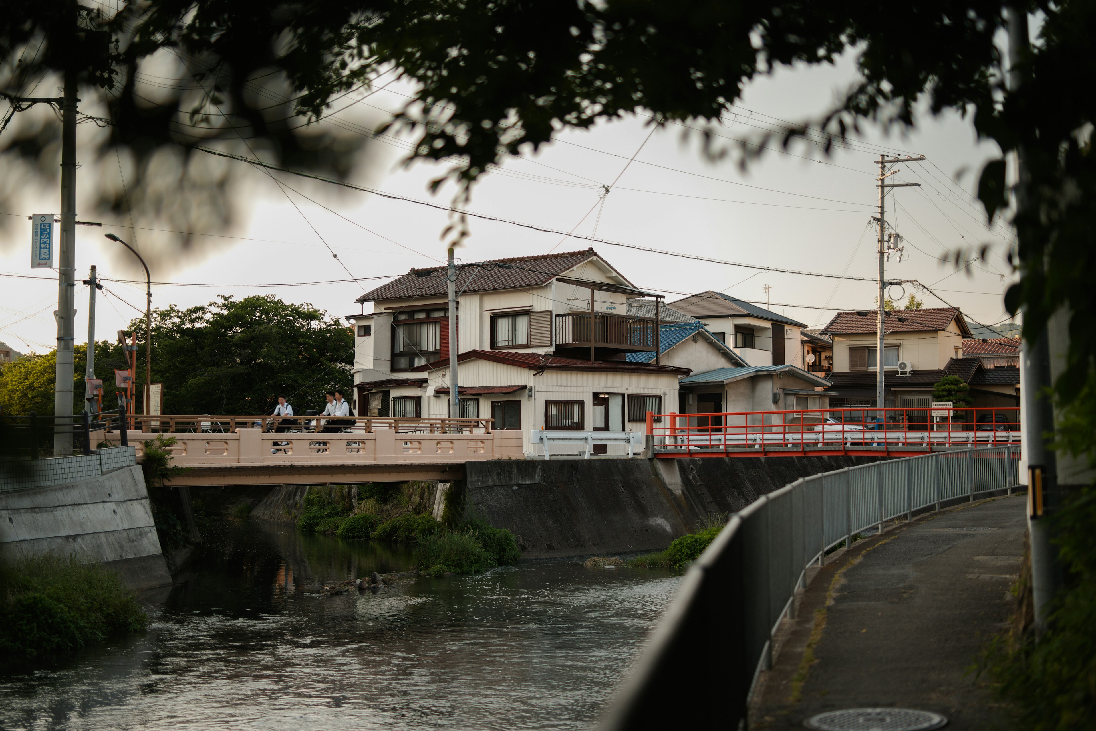 Vue pittoresque d'un quartier résidentiel près d'une rivière avec un pont et des maisons