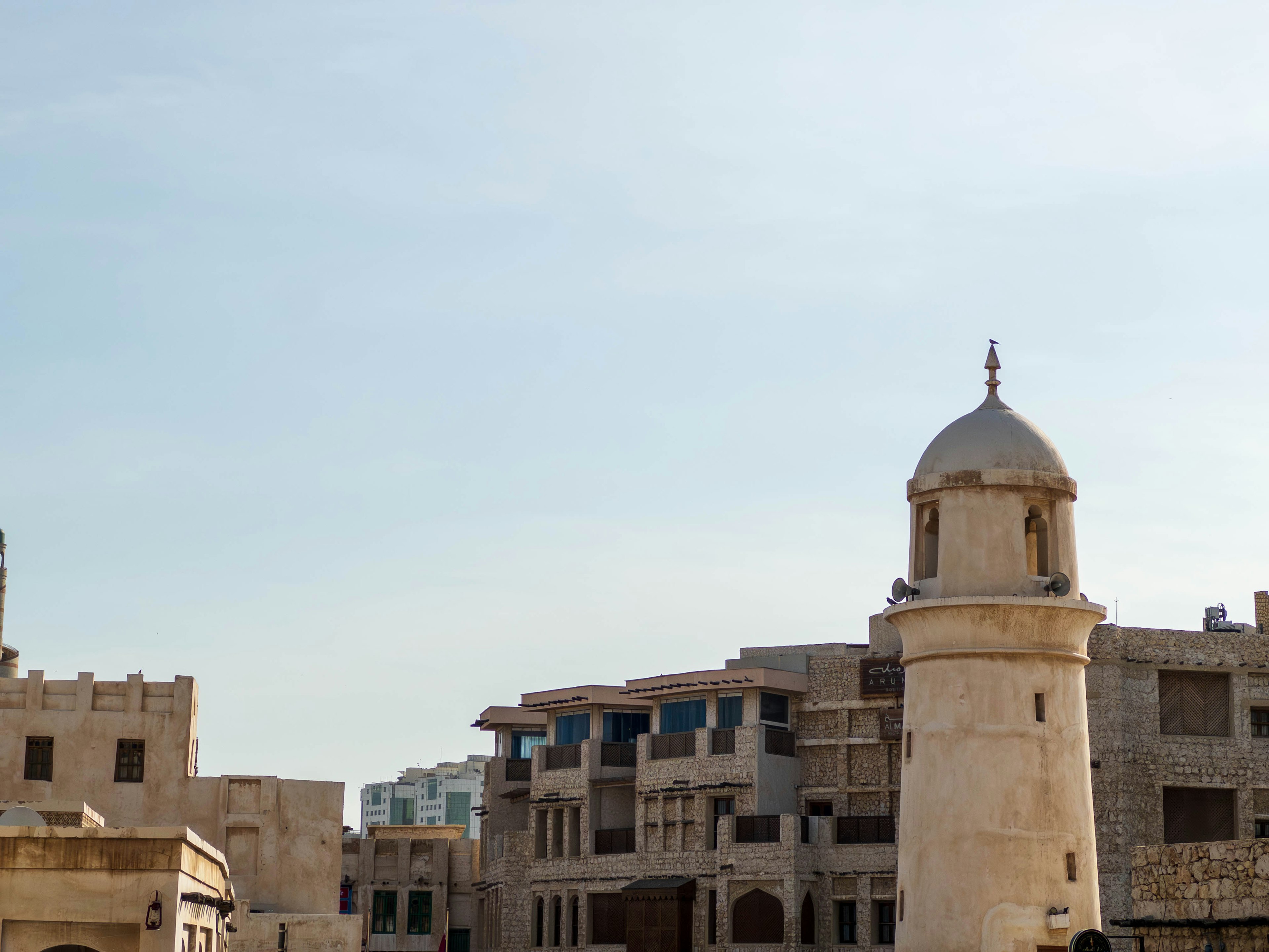 Historical buildings and a minaret under a blue sky