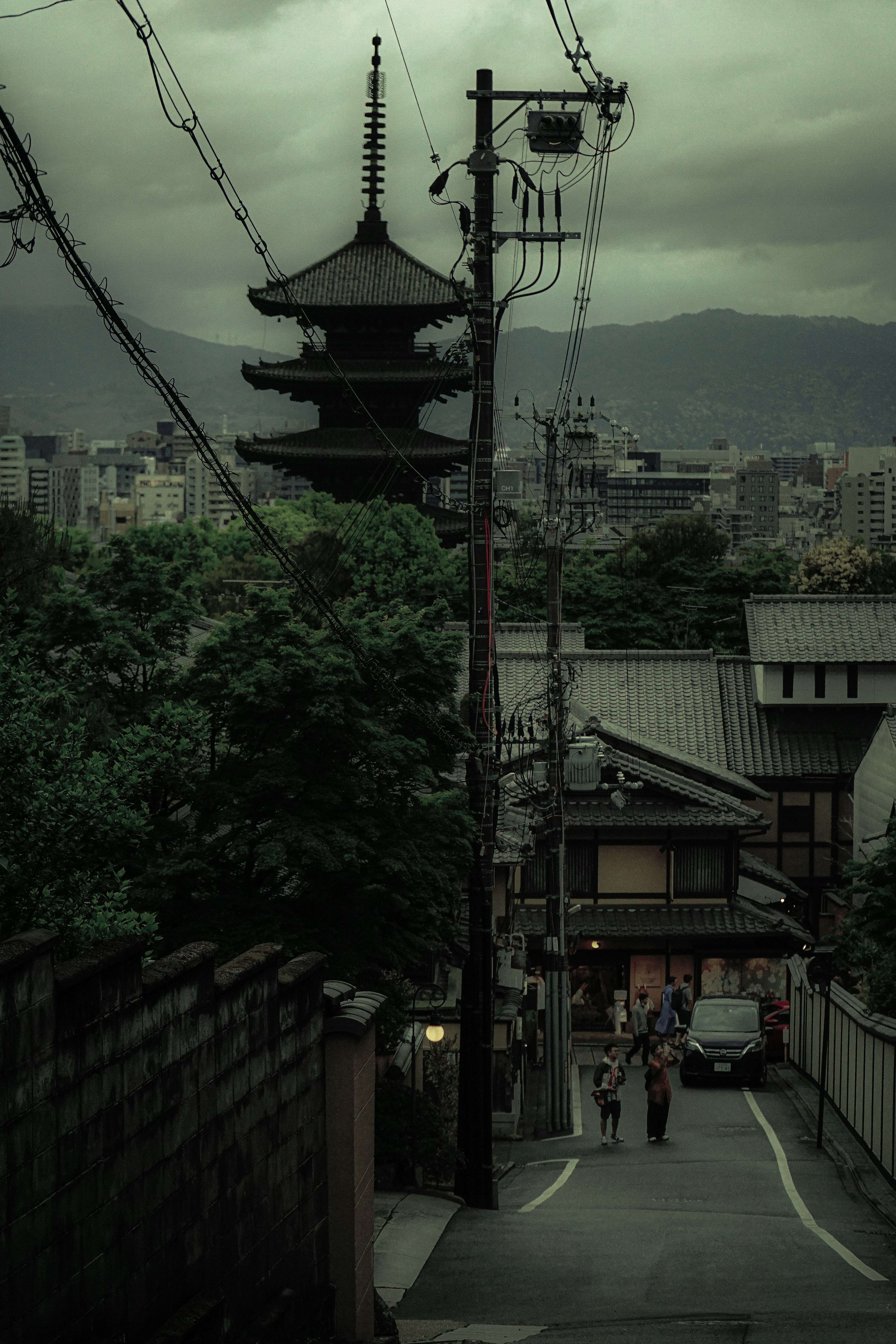 Escena de calle japonesa histórica con pagoda y cielo nublado