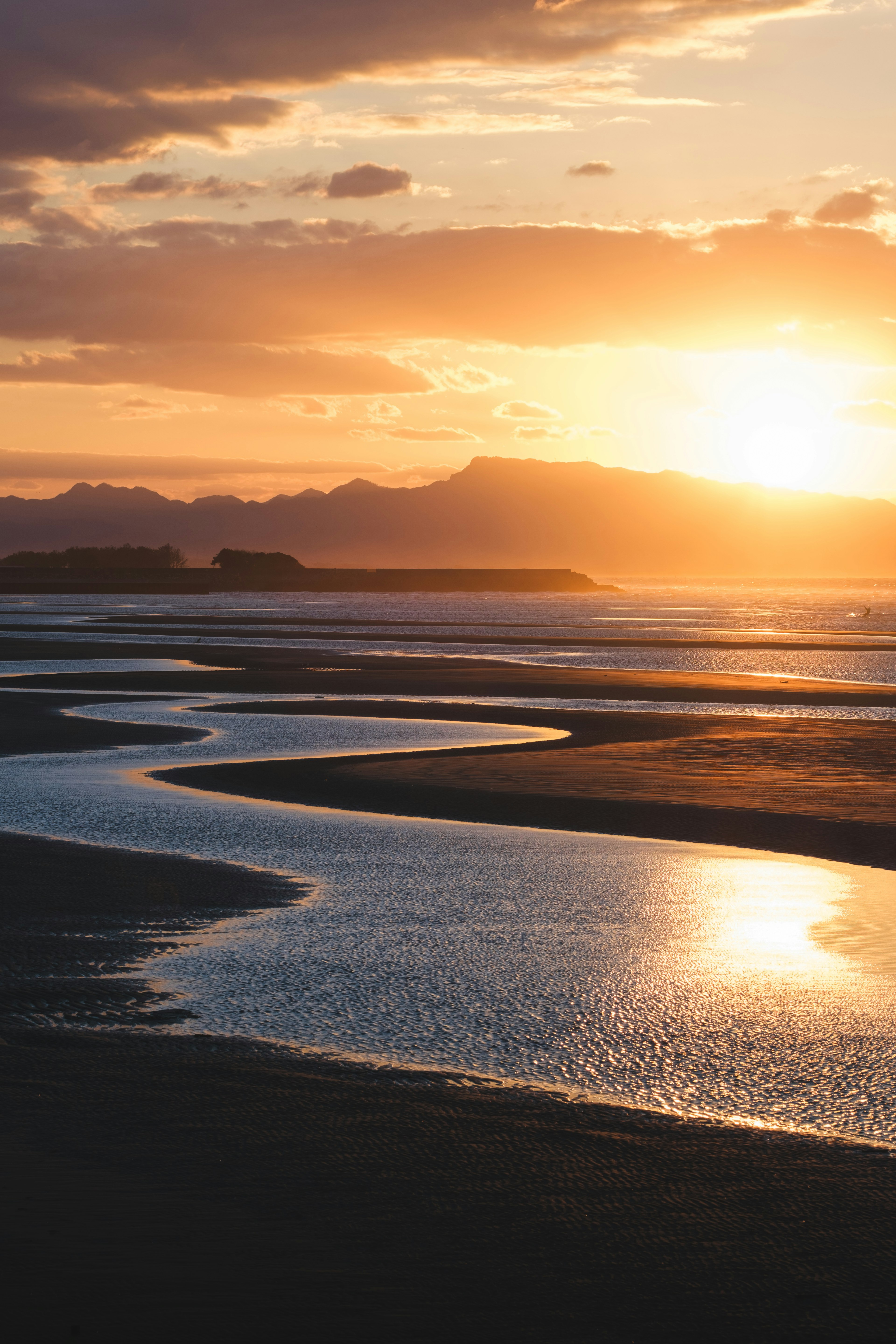 Vista escénica de una costa con un río serpenteante bajo un atardecer