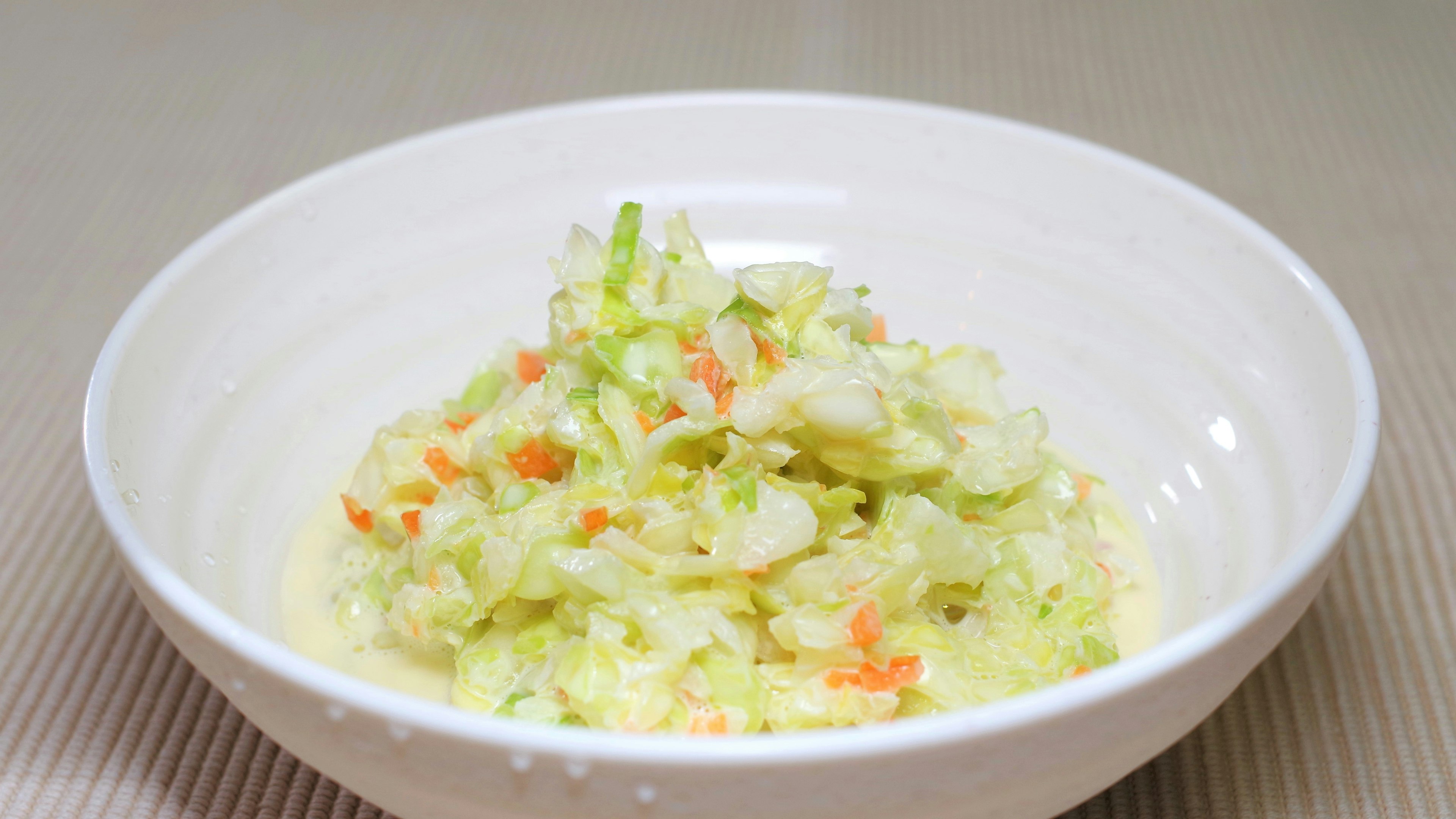 Ensalada de repollo y zanahoria fresca servida en un tazón blanco